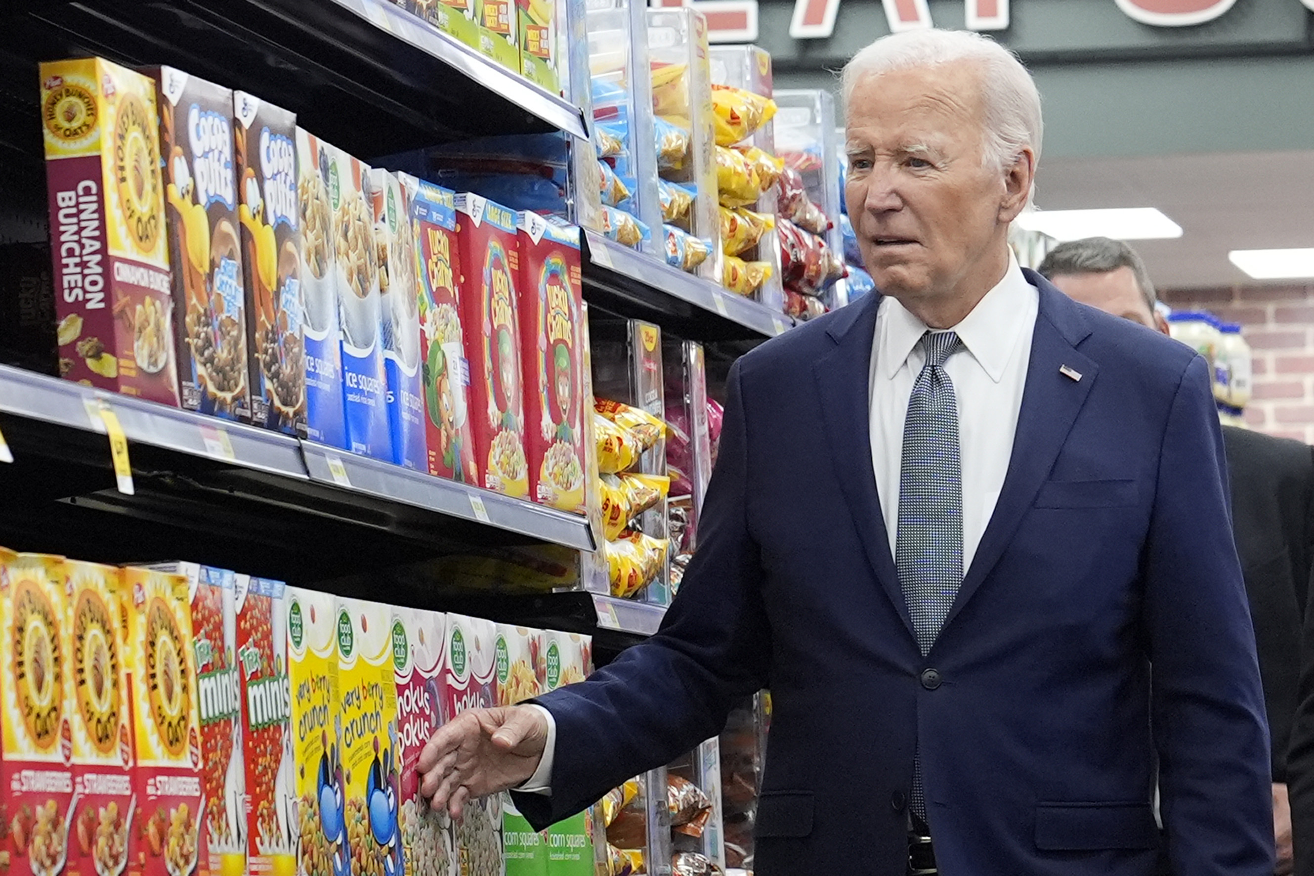 President Joe Biden walks past boxes of cereal in an aisle as he visits Mario's Westside Market in Las Vegas, Tuesday.
