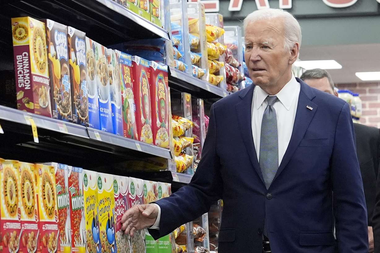 President Joe Biden walks past boxes of cereal in an aisle as he visits Mario's Westside Market in Las Vegas, Tuesday.