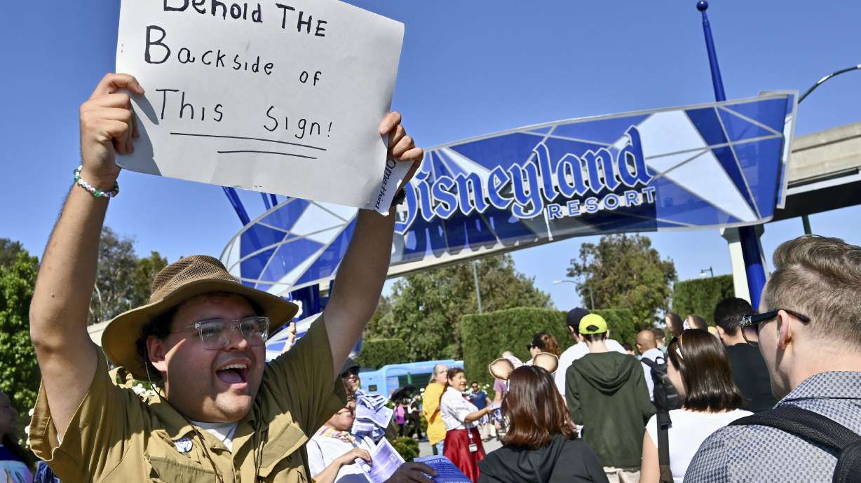 Jungle Cruise Skipper Gabriel Ramos keeps up the Jungle Cruise-style humor as he joins other Disney union members passing out buttons and ask visitors to sign a petition supporting their fight for a contract with the theme park company outside the Harbor Boulevard entrance July 1, in Anaheim, Calif.