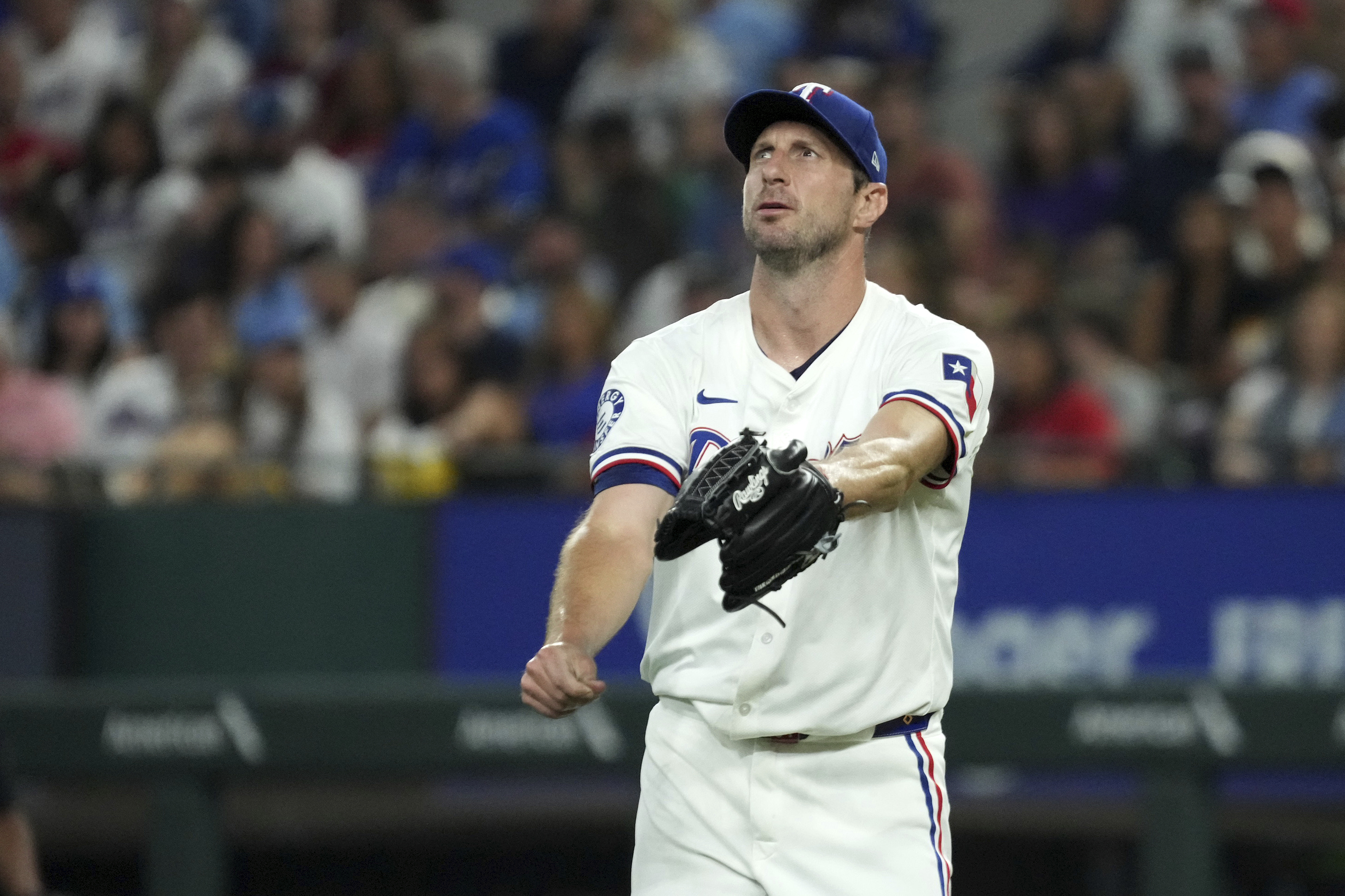 Texas Rangers starting pitcher Max Scherzer reacts after walking Baltimore Orioles' Ryan O'Hearn during the second inning of a baseball game, Saturday, July 20, 2024, in Arlington, Texas. The Orioles scored four runs in the inning. 