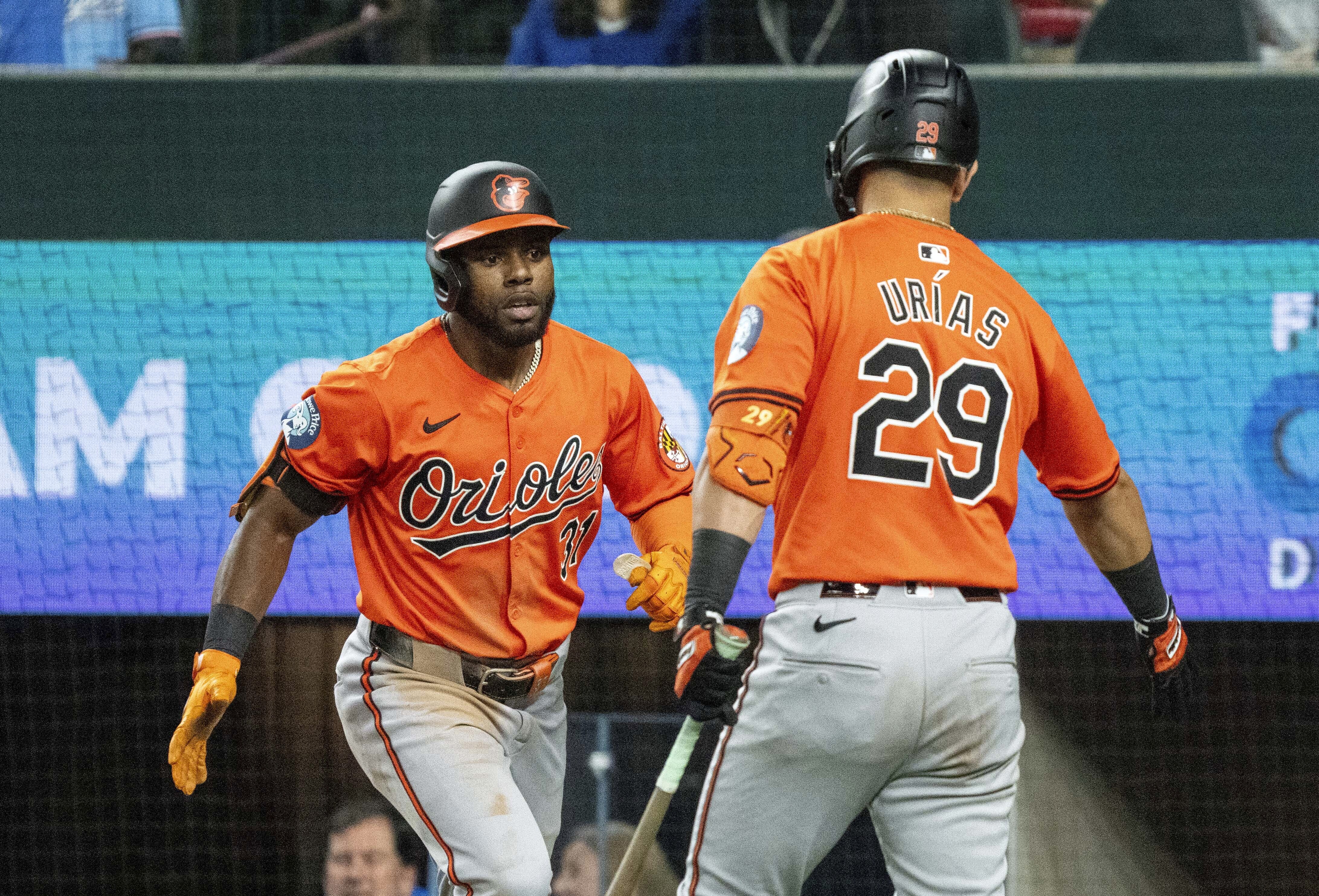 Baltimore Orioles' Cedric Mullins (31) is congratulated by Ramon Urias (29) after hitting a solo home run off of Texas Rangers relief pitcher Jose Urena during the third inning of a baseball game Saturday, July 20, 2024, in Arlington, Texas. 