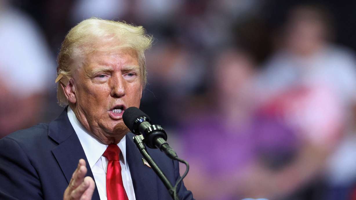 Republican presidential nominee Donald Trump wears a flesh-colored bandage on his ear as he holds a campaign rally for the first time with his running mate, Sen. JD Vance in Grand Rapids, Mich., Saturday.
