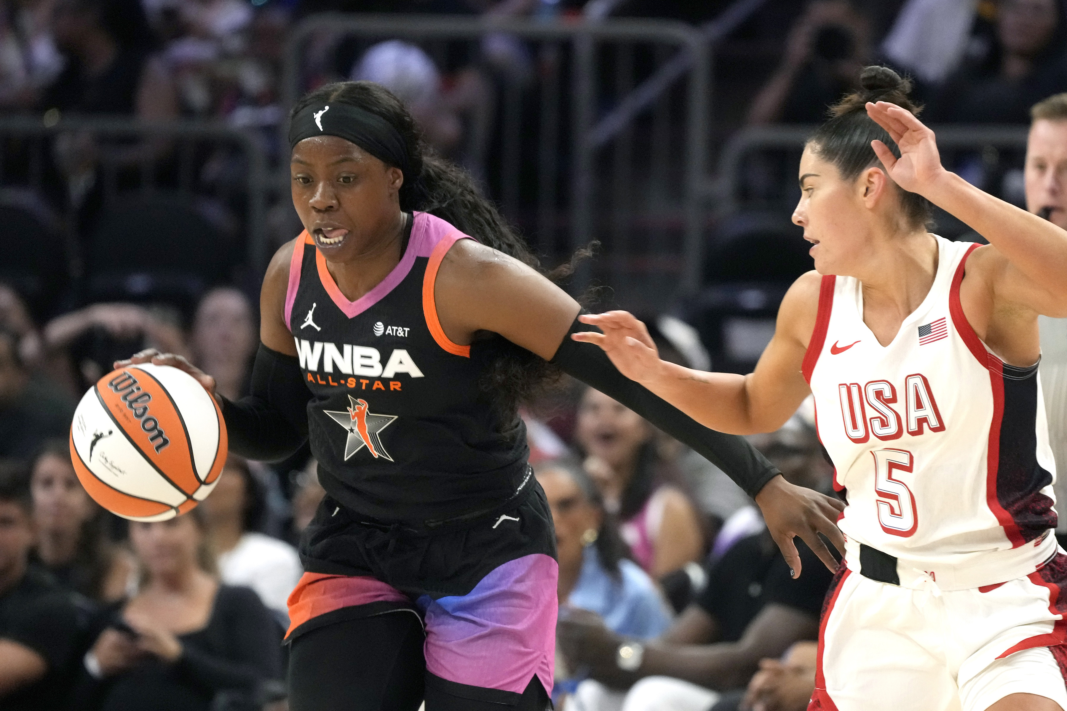 Arike Ogunbowale, left, of Team WNBA, left, steals a pass intended for Kelsey Plum (5), of Team USA, during the second half of a WNBA All-Star basketball game Saturday, July 20, 2024, in Phoenix. 