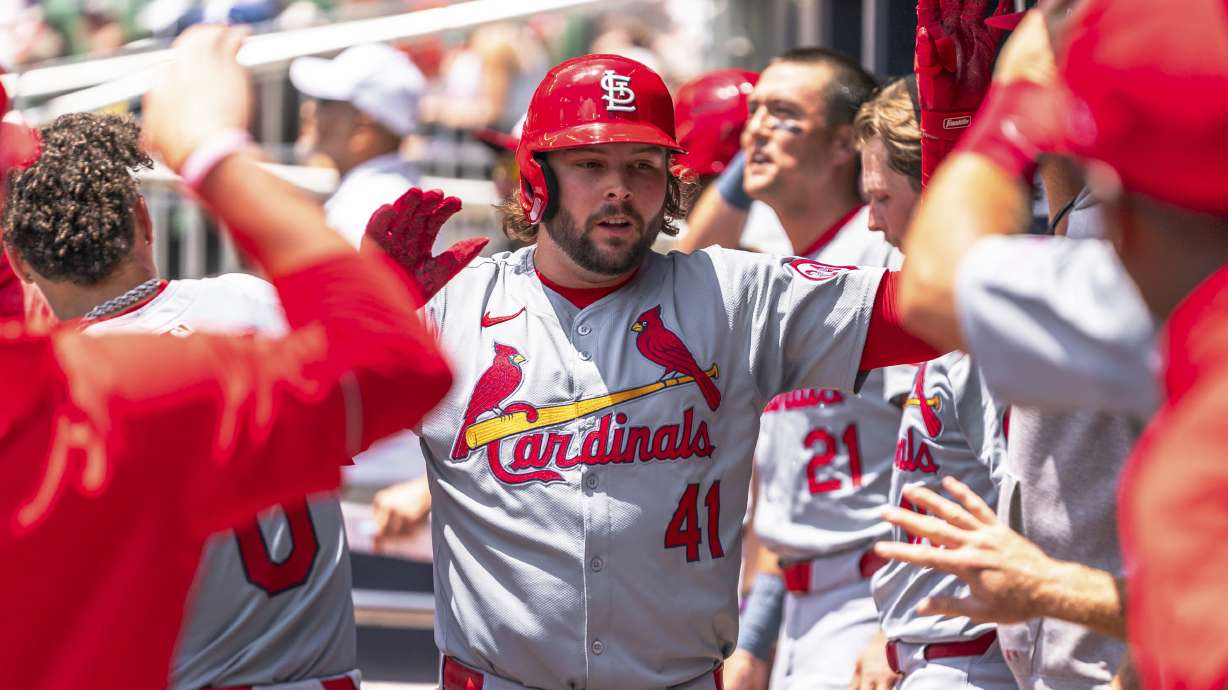 St. Louis Cardinals' Alec Burleson (41) celebrates in the dugout after hitting a home run in the third inning of a baseball game against the Atlanta Braves, Sunday, July 21, 2024, in Atlanta.