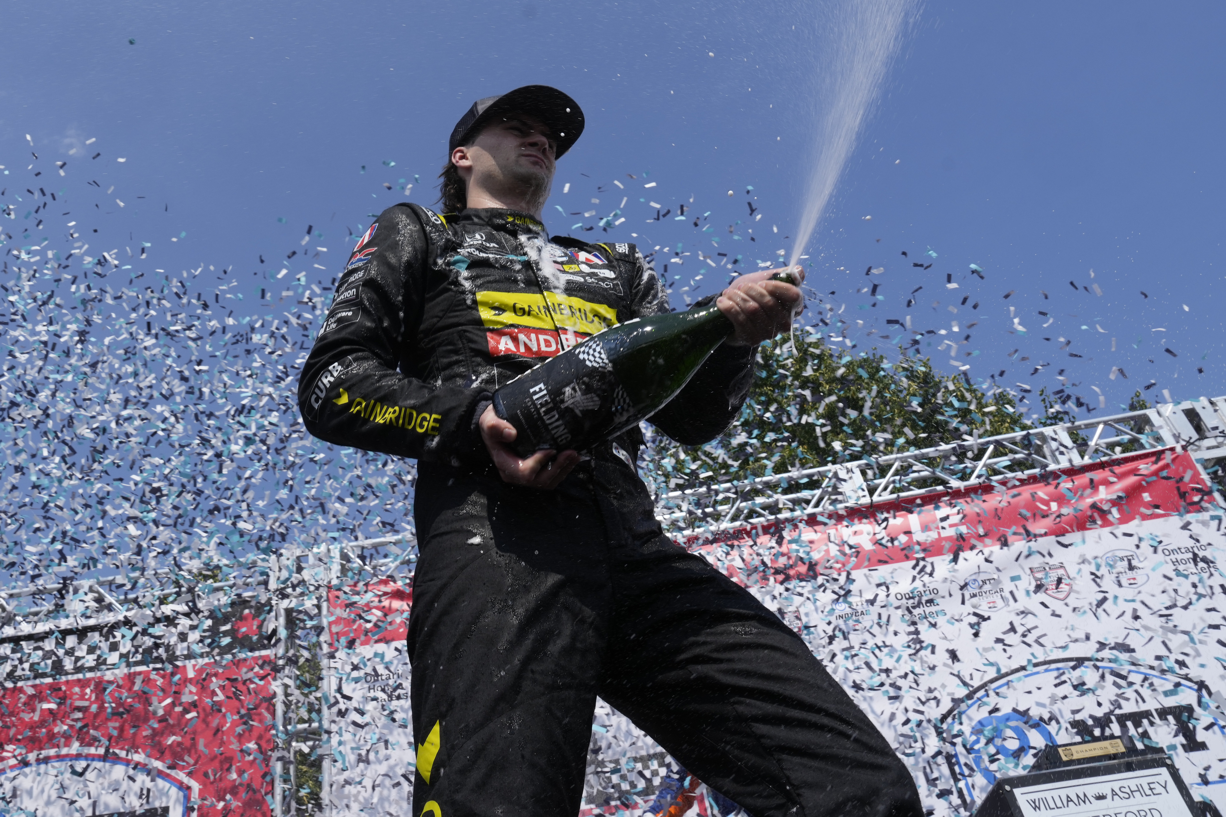 Colton Herta, of the United States, celebrates with his team after winning an IndyCar auto race in Toronto, Sunday, July 21, 2024. 