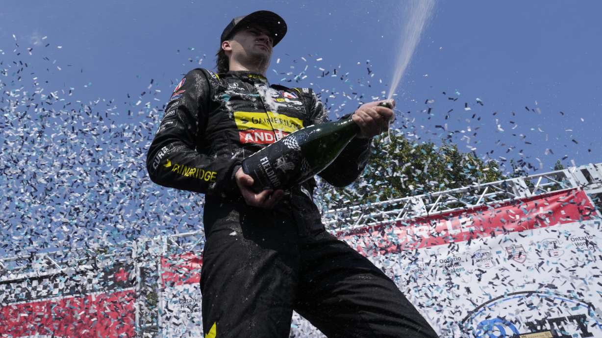 Colton Herta, of the United States, celebrates with his team after winning an IndyCar auto race in Toronto, Sunday, July 21, 2024.