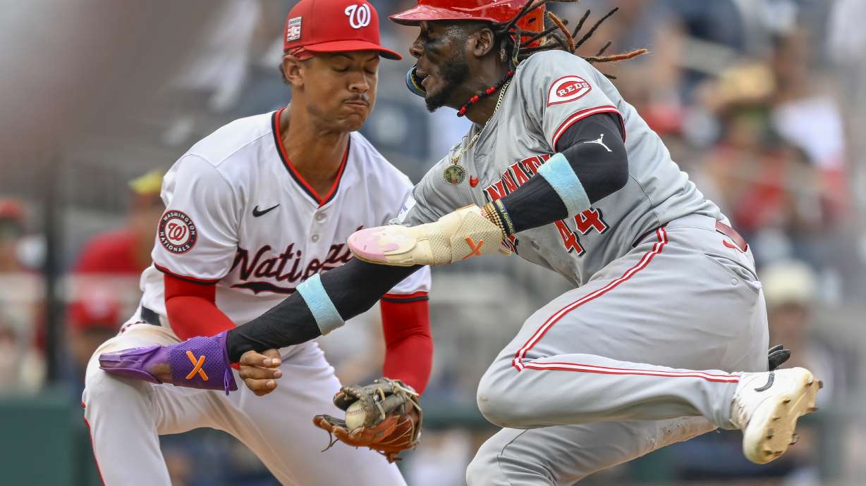 Washington Nationals third baseman Trey Lipscomb, left, tags out Cincinnati Reds' Elly De La Cruz, right, during the sixth inning of a baseball game, Sunday, July 21, 2024, in Washington.