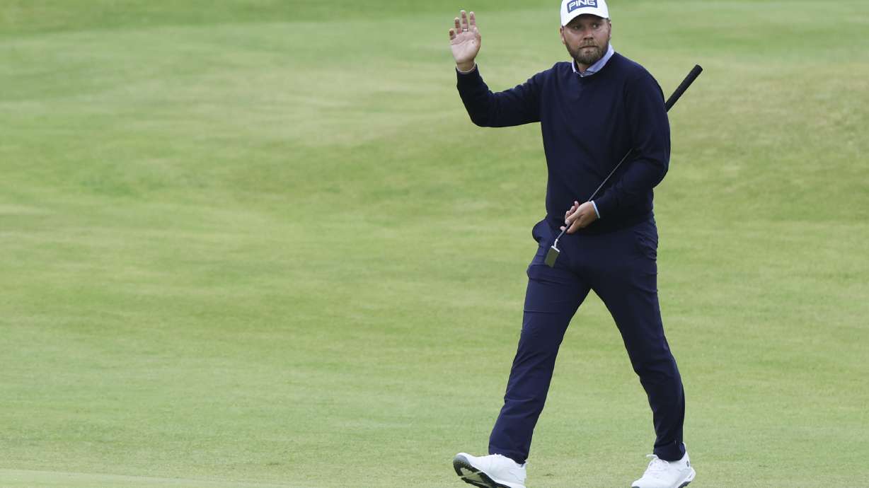 Daniel Brown of England gestures to the spectators as he walks to the 18th green during his final round of the British Open Golf Championships at Royal Troon golf club in Troon, Scotland, Sunday, July 21, 2024.