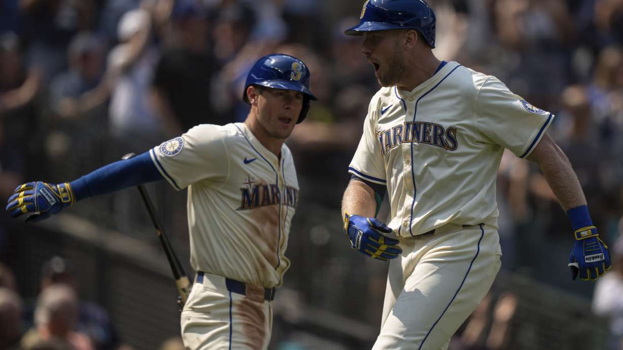 Seattle Mariners' Luke Raley, right, celebrates with Dylan Moore after hitting a three-run home run during the sixth inning of a baseball game against the Houston Astros, Sunday, July 21, 2024, in Seattle.