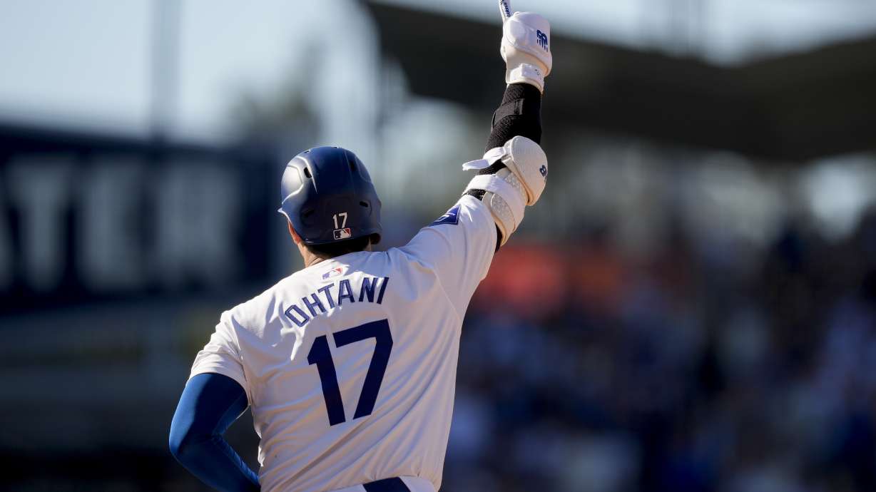Los Angeles Dodgers designated hitter Shohei Ohtani celebrates while running the bases after hitting a solo home run during the fifth inning of a baseball game against the Boston Red Sox, Sunday, July 21, 2024, in Los Angeles.