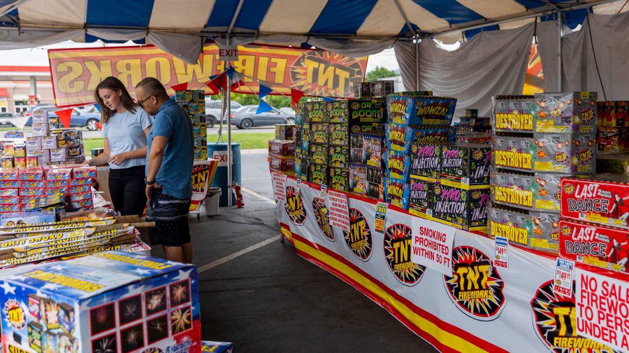 Karlie Roberts sells fireworks to Sam Khadka at a TNT tent selling fireworks in Salt Lake City on July 1. Gov. Spencer Cox said he wants Utahns to be careful with lighting any personal fireworks for Pioneer Day as wildfire conditions worsen.