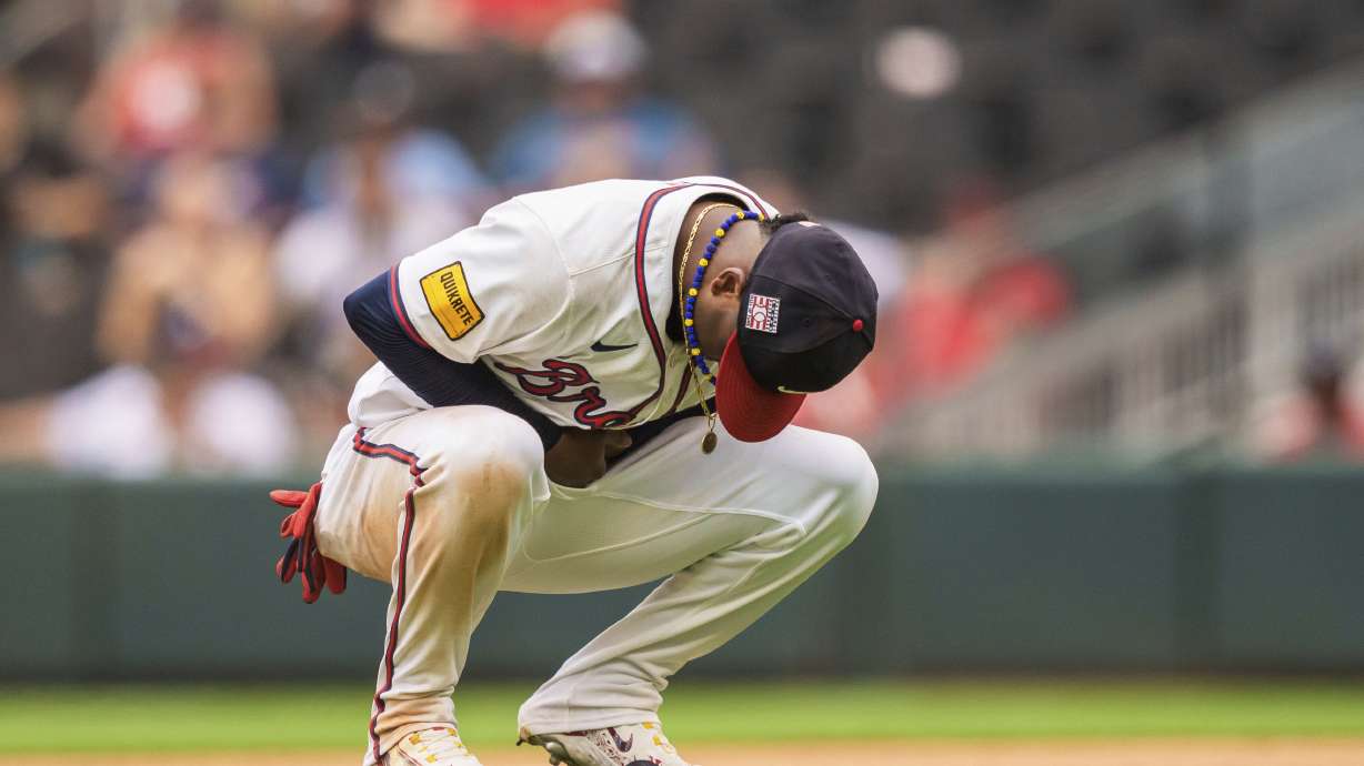 CORRECTS TO NINTH INNING NOT EIGHTH INNING - Atlanta Braves second baseman Ozzie Albies holds his wrist after an injury in the ninth inning of a baseball game against the St. Louis Cardinals, Sunday, July 21, 2024, in Atlanta.