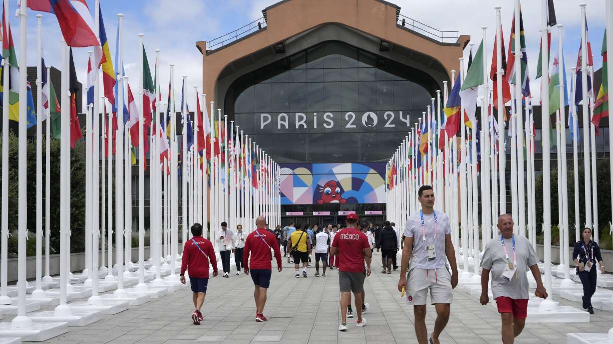 FILE - People walk in front of the canteen in the Olympic Village, at the 2024 Summer Olympics, Monday, July 22, 2024, in Paris, France.