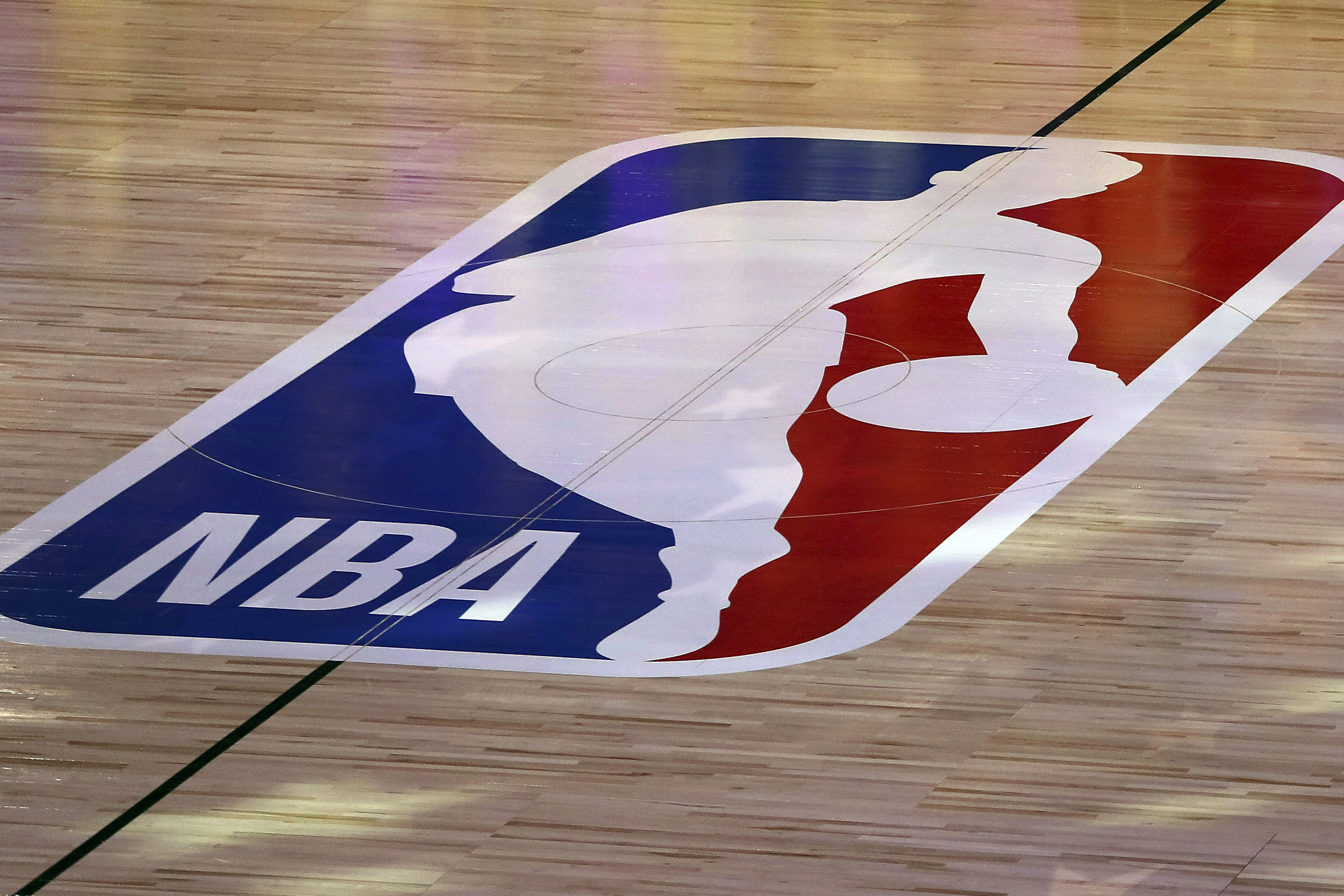 FILE - An NBA logo is seen at center court prior to an NBA basketball game between the Los Angeles Clippers and the Los Angeles Lakers, Thursday, July 30, 2020, in Lake Buena Vista, Fla. The NBA has agreed to terms on its new media deal, an 11-year agreement worth $76 billion that assures player salaries will continue rising for the foreseeable future and one that will surely change how some viewers access the game for years to come.