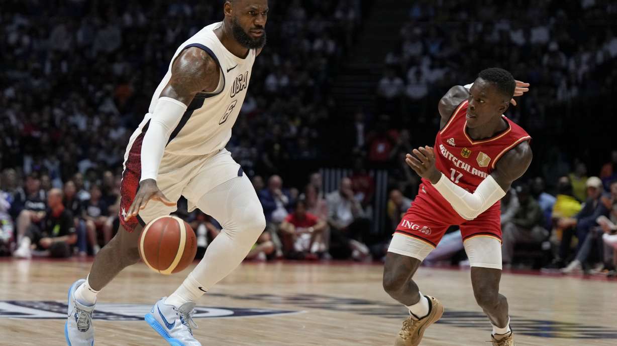 United States' forward LeBron James, left, and Germany's guard Dennis Schroeder challenge for the ball during an exhibition basketball game between the United States and Germany at the O2 Arena in London, Monday, July 22, 2024.
