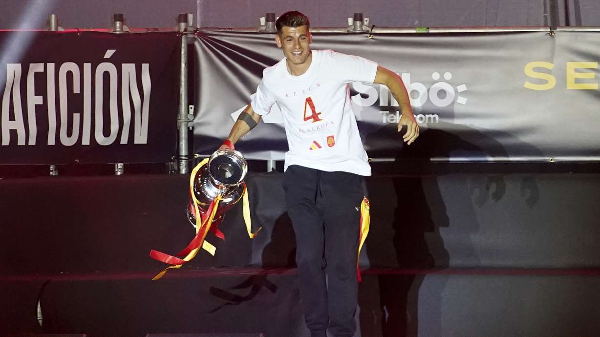 Spain's team captain Alvaro Morata arrives on stage carrying the trophy during celebrations of the Spanish team's European soccer championship title on a stage at Cibeles square in Madrid, Monday, July 15, 2024. Spain defeated England in the final of the Euro 2024 soccer tournament in Berlin on Sunday evening.