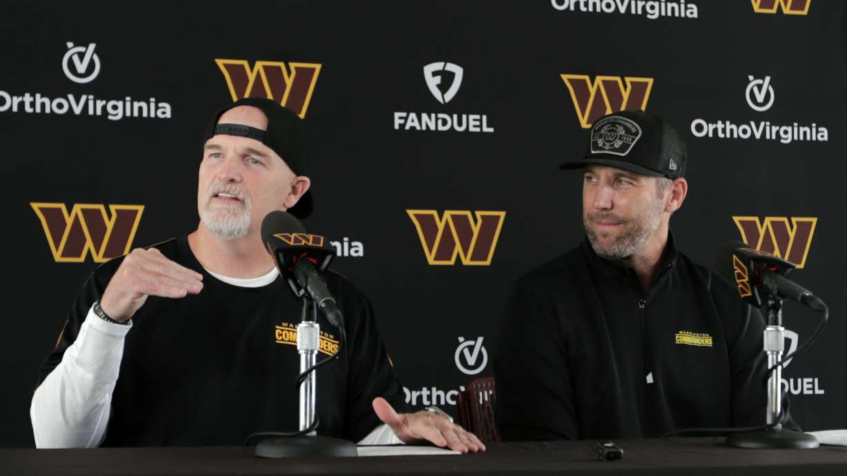 Washington Commanders head coach Dan Quinn, left, speaks as general manager Adam Peters, right, looks on during an NFL football press conference in Ashburn, Va., Tuesday, July 23, 2024.