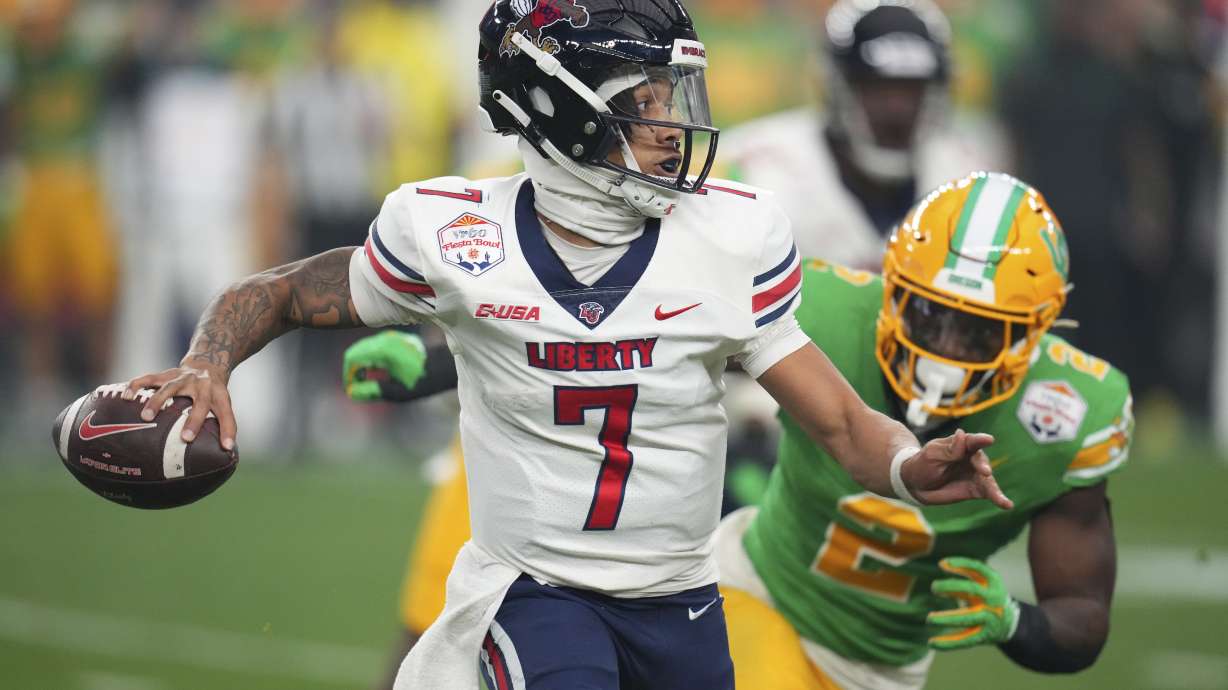 FILE - Liberty quarterback Kaidon Salter (7) scrambles during the first half on the NCAA Fiesta Bowl college football game against Oregon, on Jan. 1, 2024, in Glendale, Ariz. Liberty is favored to repeat as Conference USA champion with Western Kentucky and Jacksonville State picked behind the Flames, according to a poll of media members who cover the league.