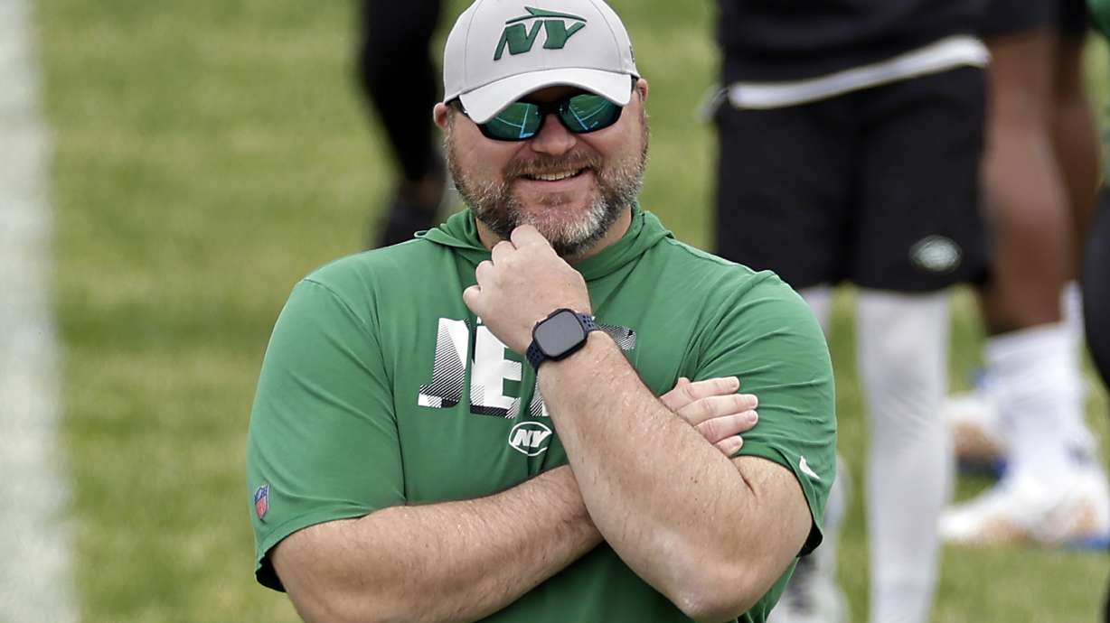 FILE - New York Jets general manager Joe Douglas watches NFL rookie minicamp football practice Friday, May 3, 2024, in Florham Park, N.J. Juggling rosters has become a strategic art for NFL general managers. Teams enter training camp with a maximum of 90 players, who work through long, hot practices trying to prove they should be among the 53 on the active roster heading into the regular season.