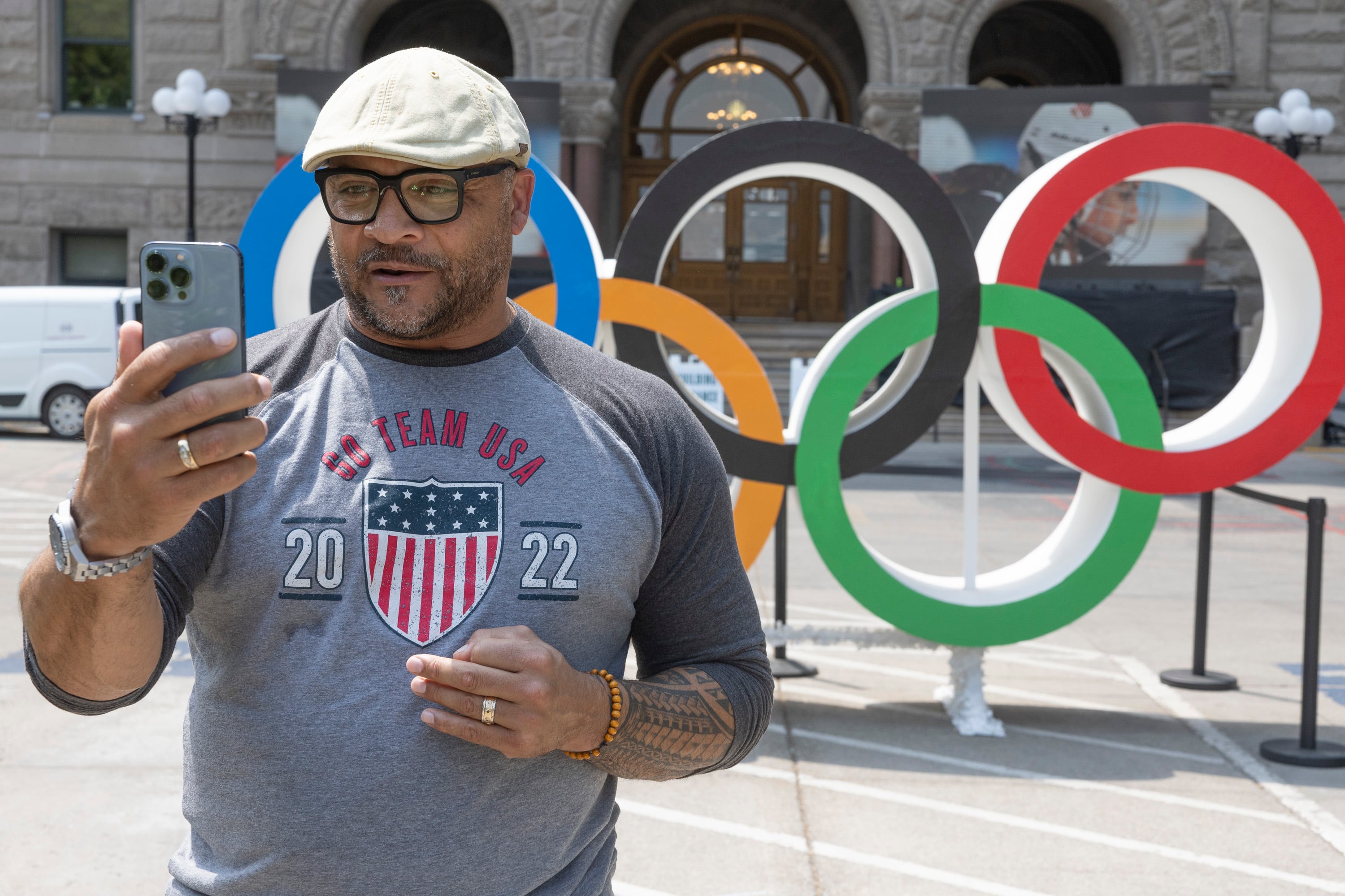 Bill Schuffenhauer, a 2002 bobsled silver medalist and the executive committee president for Utah and United States Olympic and Paralympic Alumni, takes a video in front of the Olympic rings in Washington Square ahead of the live watch party for the Salt Lake City-Utah Committee’s 2034 Winter Olympics bid at the Salt Lake City and County Building on Tuesday in downtown Salt Lake City.
