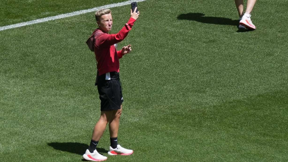 Coach Beverly Priestman of Canada takes photos on the pitch at Geoffroy-Guichard Stadium ahead of the 2024 Summer Olympics, Tuesday, July 23, 2024, in Saint-Etienne, France. Canada is scheduled to play New Zealand on Thursday, July 25.