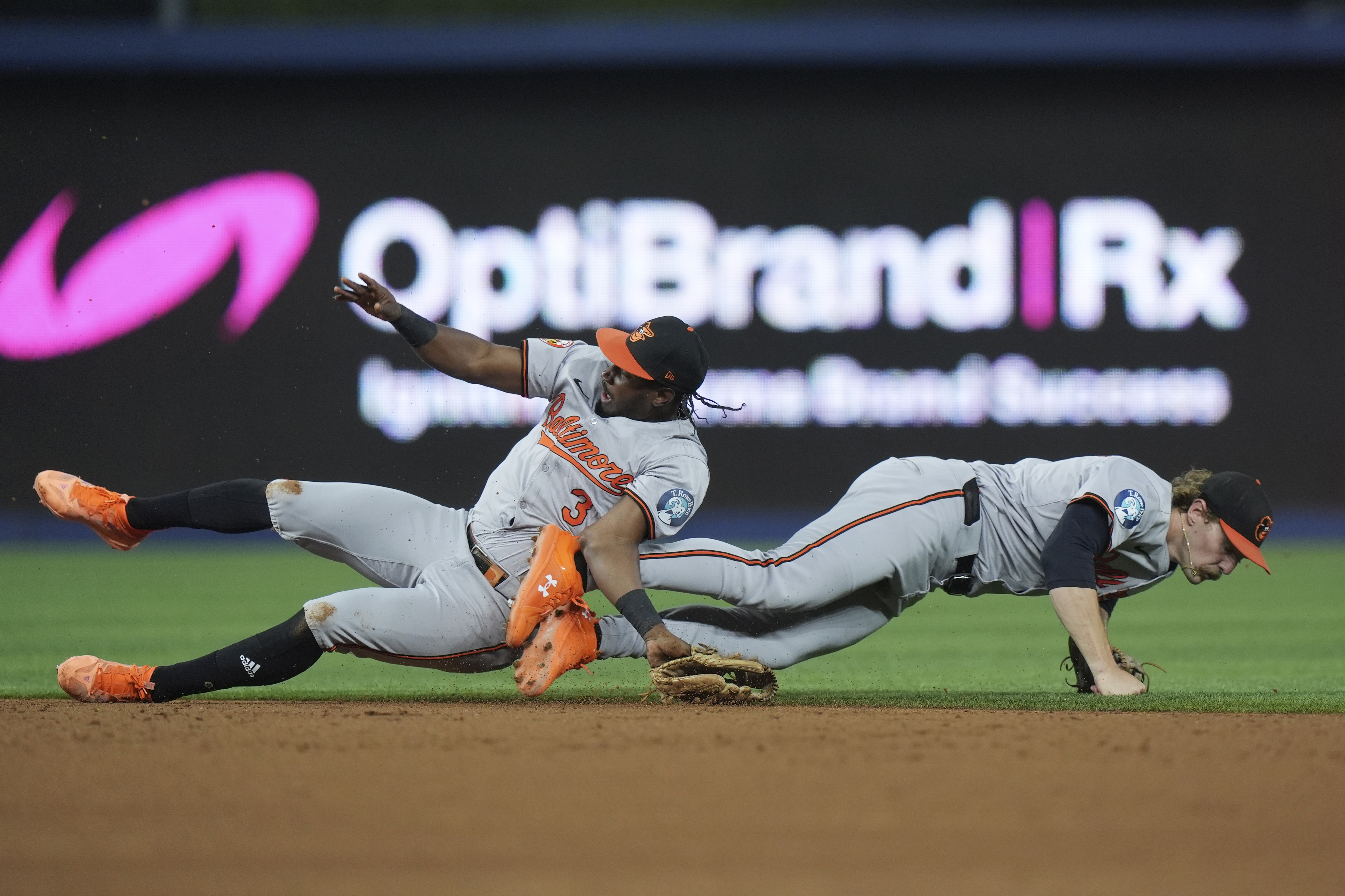 Baltimore Orioles second baseman Jorge Mateo, left, and shortstop Gunnar Henderson collide as they vie for a ball hit by Miami Marlins' Jesús Sánchez during the third inning of a baseball game, Tuesday, July 23, 2024, in Miami. Mateo was helped off the field after the play. 