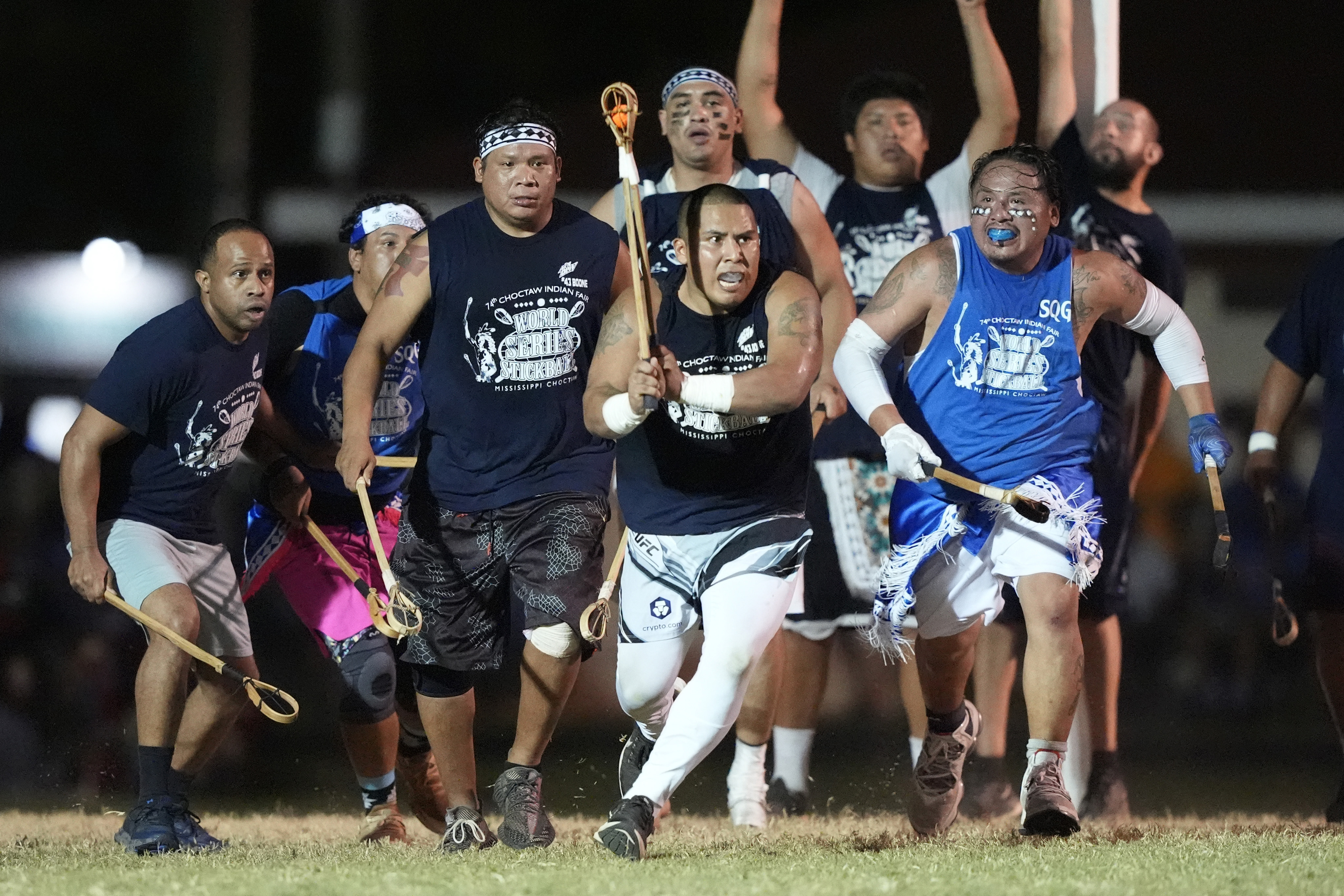 Pearl River's Kanyon Jimmie sprints with the "towa," or ball, while pursed by teammates and a Koni Hata defender during the Men's Division of the World Series of Stickball title game, hosted by the Mississippi Band of Choctaw Indians, Saturday, July 13, 2024, in Choctaw, Miss. With the exception of some wearing mouth guards, the players wear no padding in the full-contact game, which is the precursor to lacrosse.
