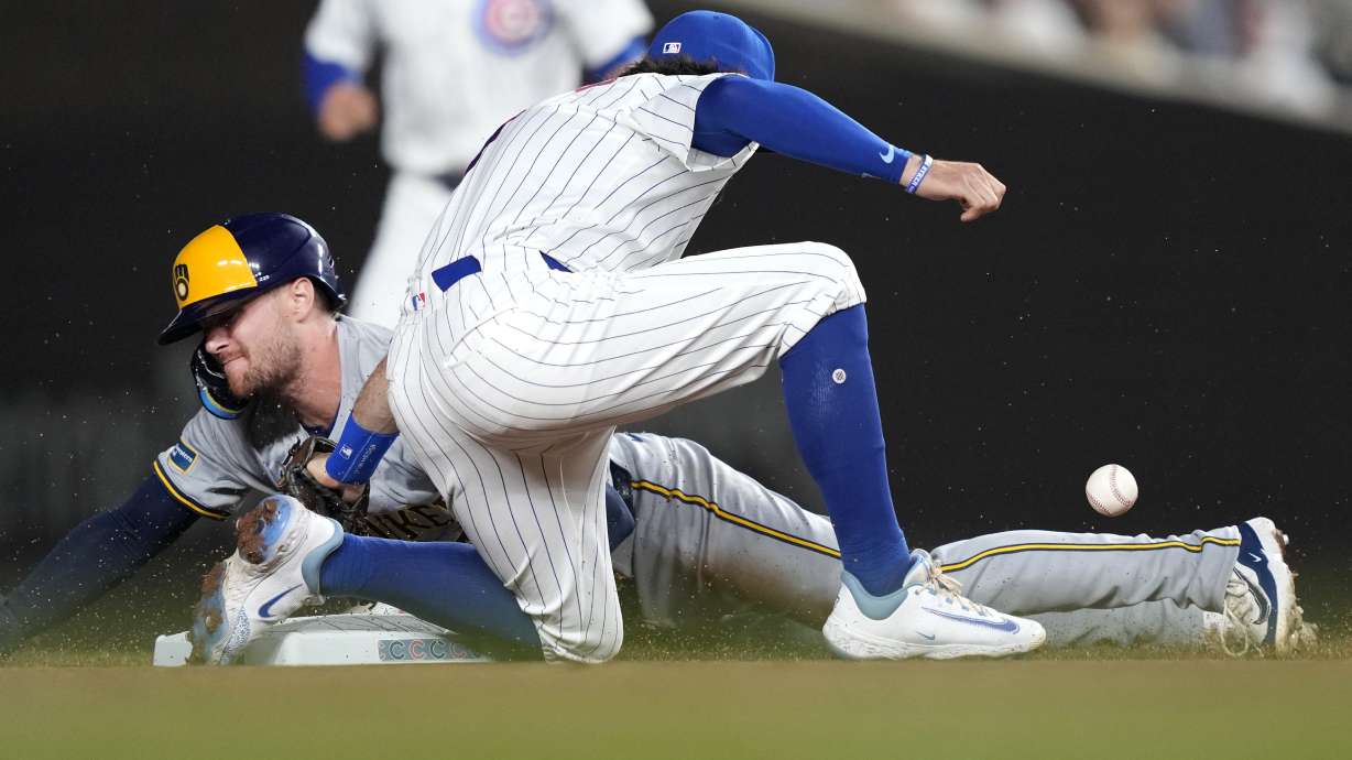 Milwaukee Brewers' Brice Turang steals second as Chicago Cubs' Dansby Swanson is unable to handle a throw from catcher Miguel Amaya during the first inning of a baseball game, Tuesday, July 23, 2024, in Chicago.
