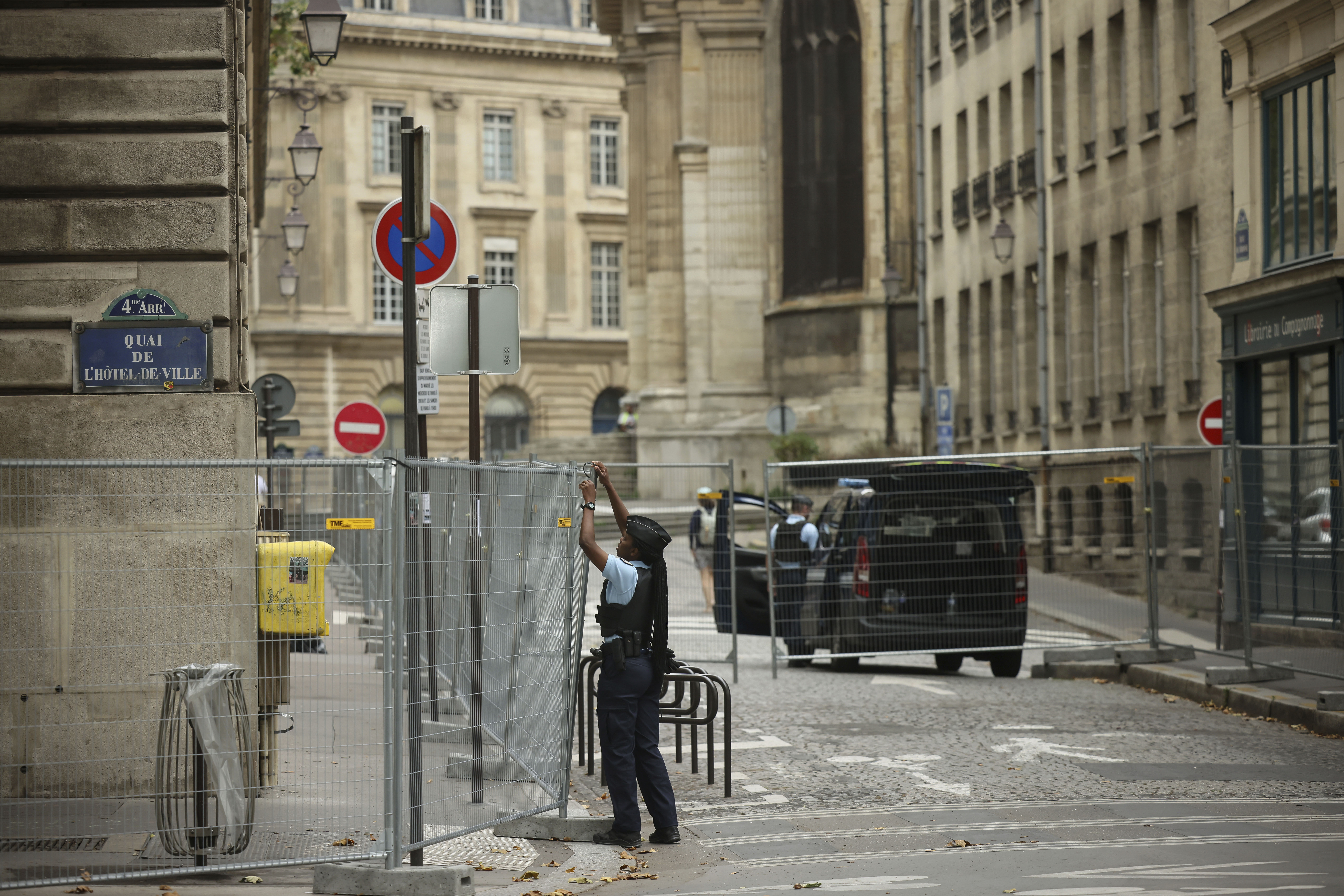 FILE - A police officer attaches fences at the security perimeter at the 2024 Summer Olympics, Sunday, July 21, 2024, in Paris, France.T hree days before the start of the Olympics, France's Interior Minister has hailed the country’s law enforcement for their hard work in making the Paris Games safe for 10,500 athletes and millions of visitors.