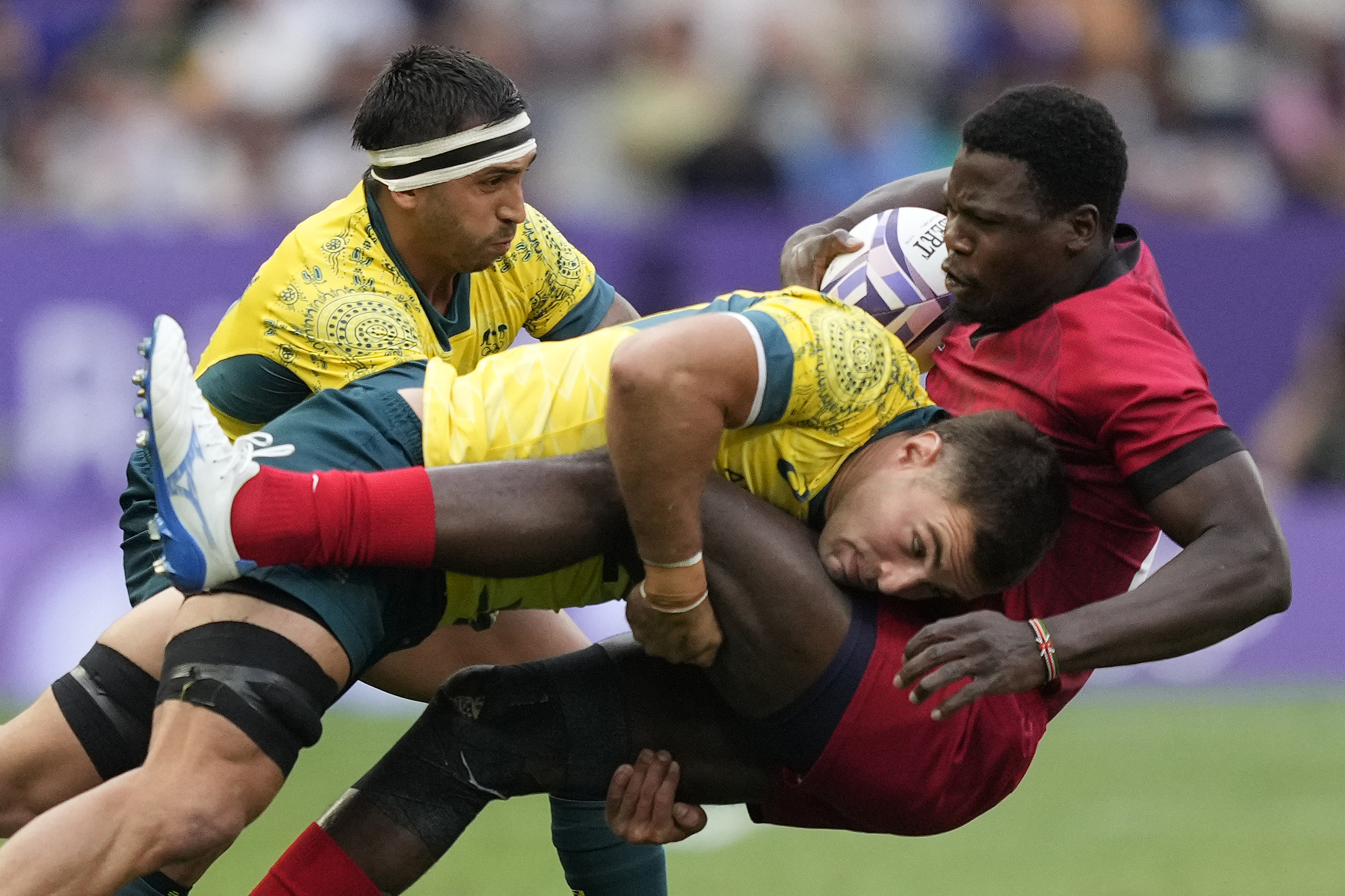 Australia's Nathan Lawson, left, tackles Kenya's Vincent Onyala during the men's Rugby Sevens Pool B match between Australia and Kenya at the 2024 Summer Olympics, in the Stade de France, Saint-Denis, France, Wednesday, July 24, 2024. 