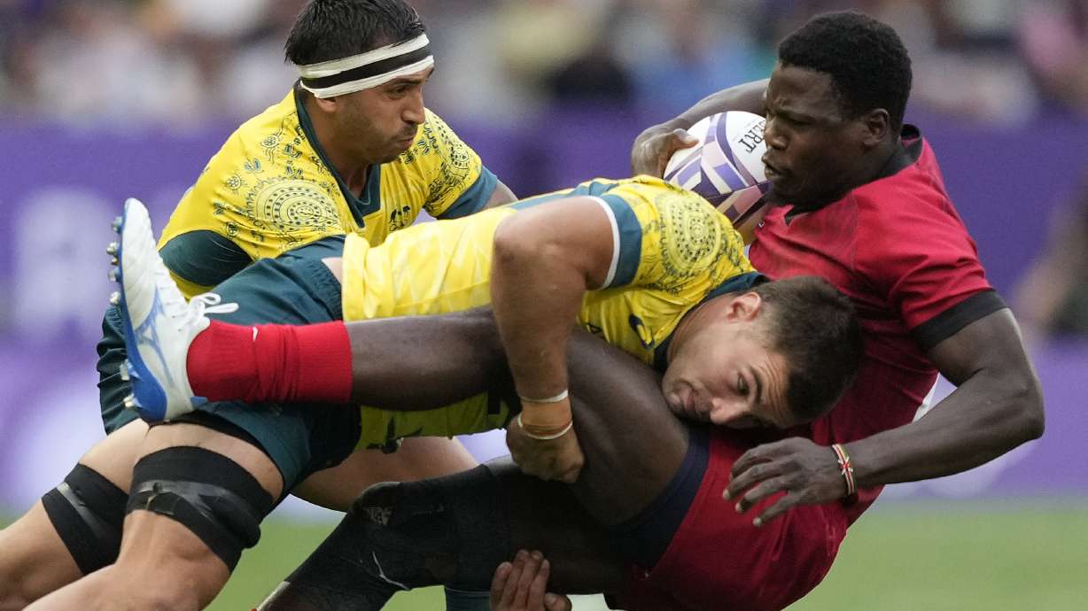Australia's Nathan Lawson, left, tackles Kenya's Vincent Onyala during the men's Rugby Sevens Pool B match between Australia and Kenya at the 2024 Summer Olympics, in the Stade de France, Saint-Denis, France, Wednesday, July 24, 2024.