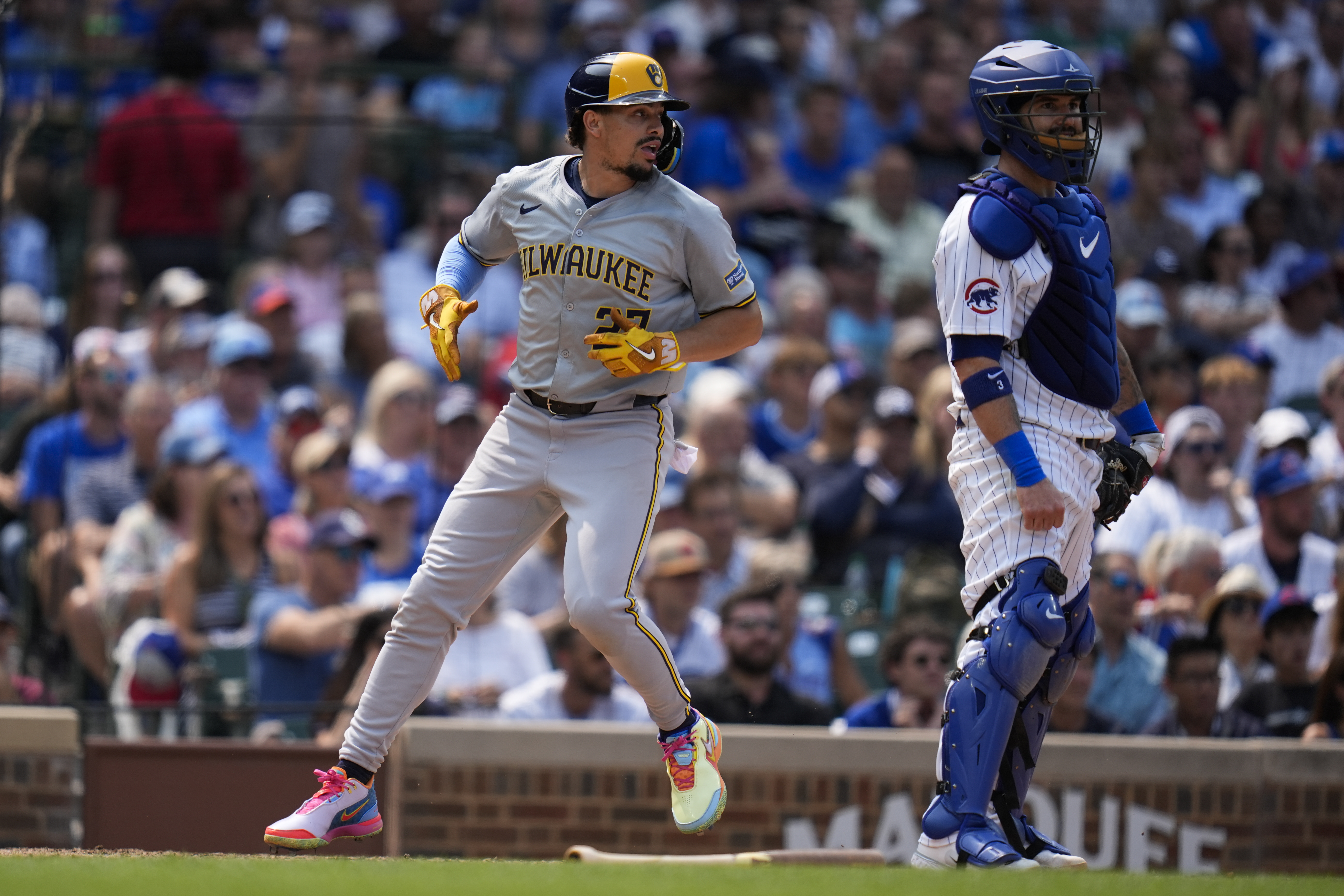 Milwaukee Brewers' Willy Adames jogs past Chicago Cubs catcher Tomás Nido to score on a single from Brice Turang during the sixth inning of a baseball game Wednesday, July 24, 2024, in Chicago. 