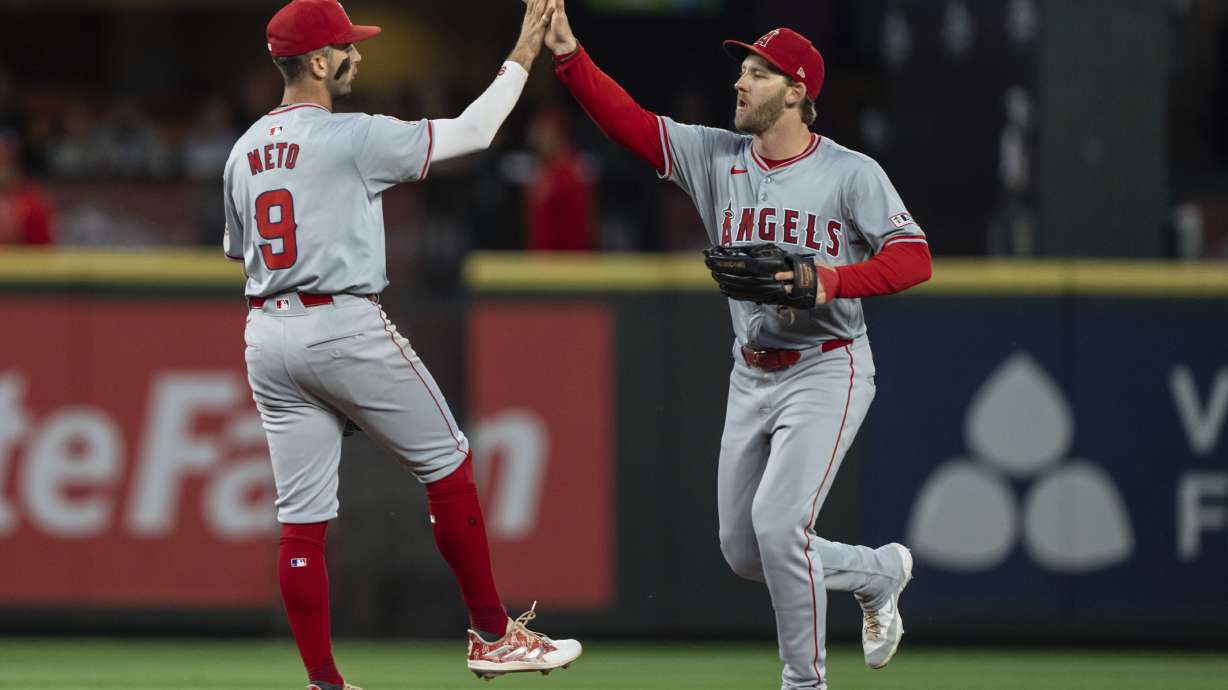Los Angeles Angels' Zach Neto, left, and Taylor Ward celebrate after a baseball game against the Seattle Mariners, Tuesday, July 23, 2024, in Seattle.