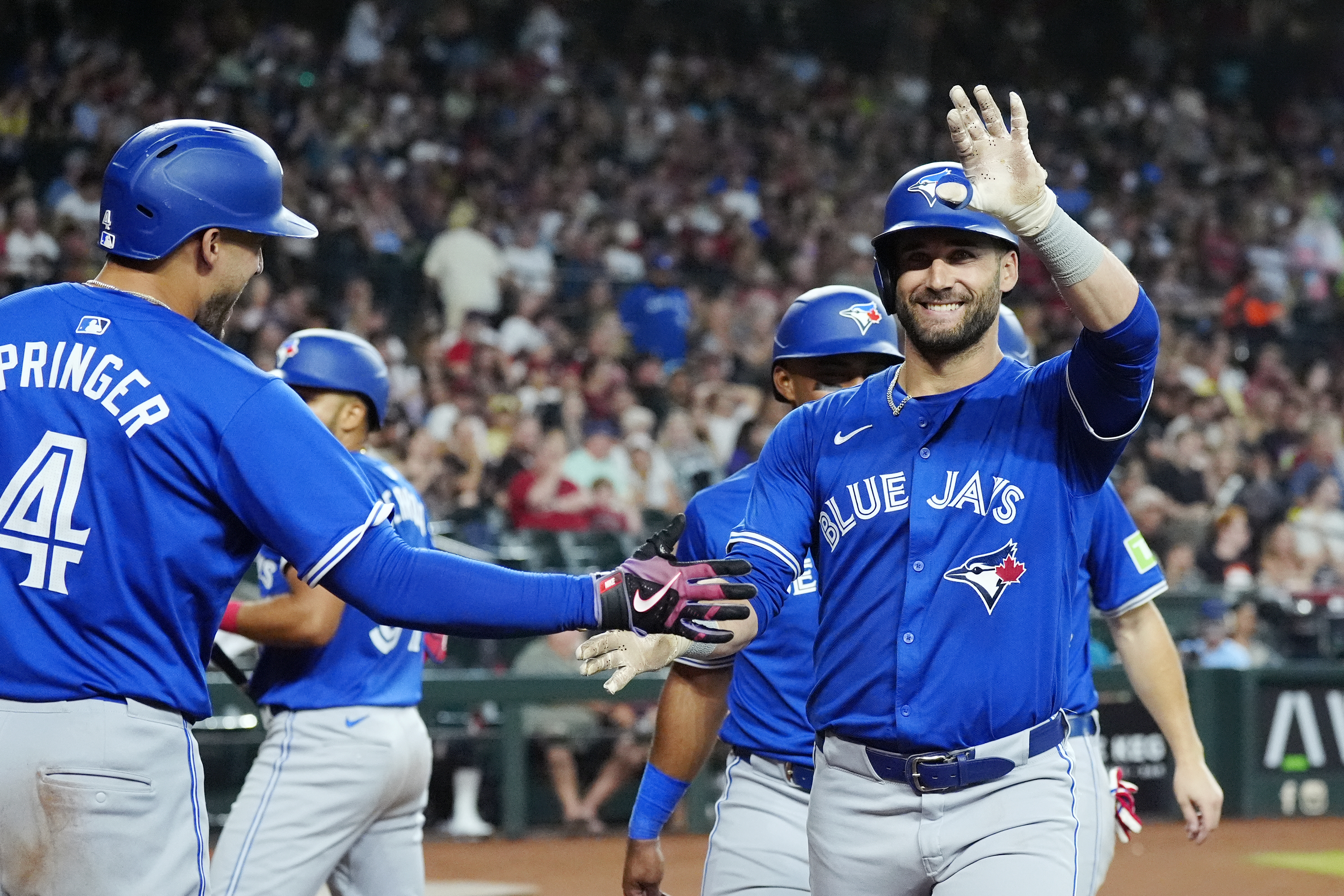 Toronto Blue Jays' Kevin Kiermaier, right, waves to the crowd as he celebrates his grand slam against the Arizona Diamondbacks with Blue Jays' George Springer (4) during the fourth inning of a baseball game, Sunday, July 14, 2024, in Phoenix. 