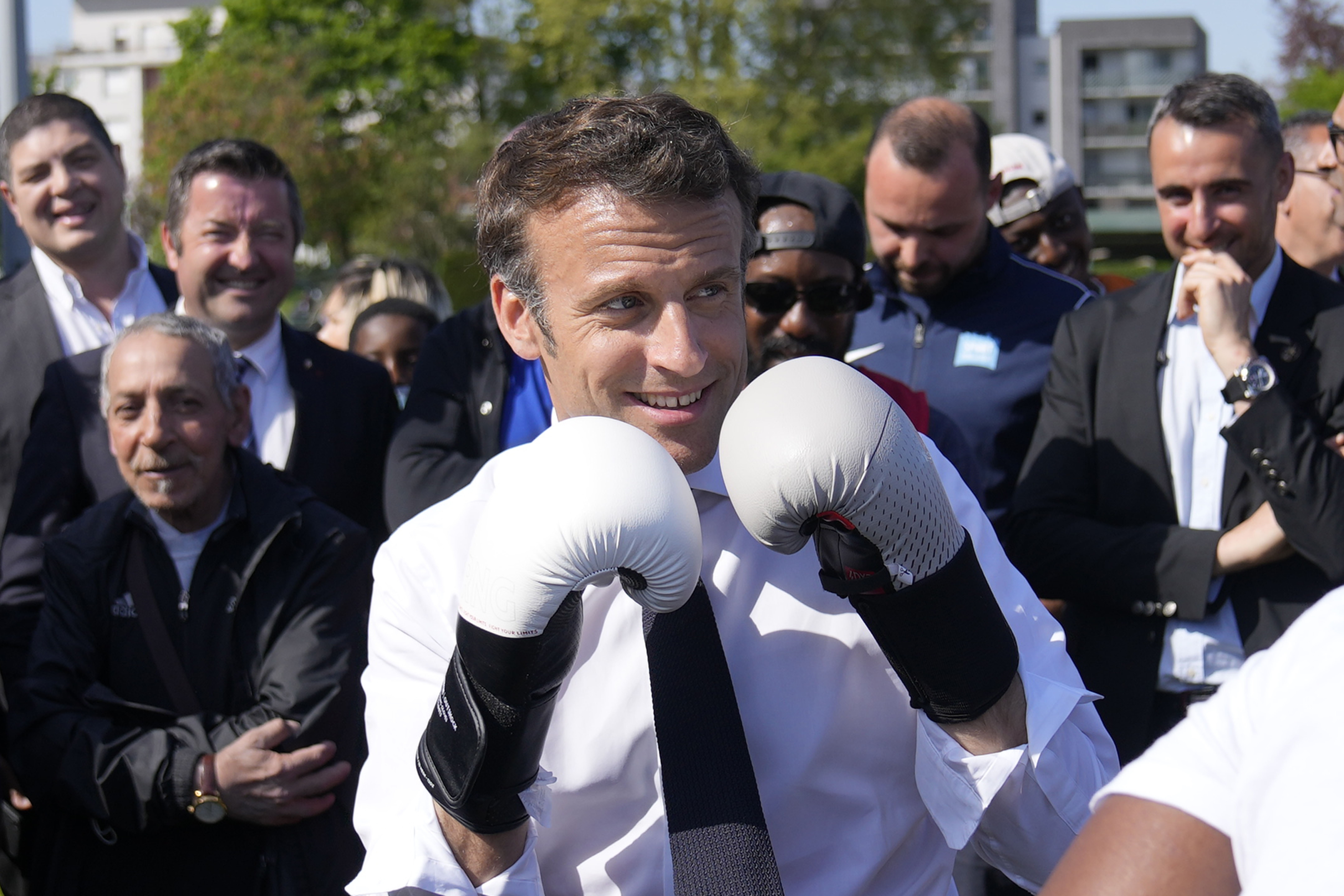 FILE - Centrist presidential candidate and French President Emmanuel Macron wears boxing gloves as he campaigns in the Auguste Delaune stadium, Thursday, April 21, 2022, in Saint-Denis, outside Paris, France. 