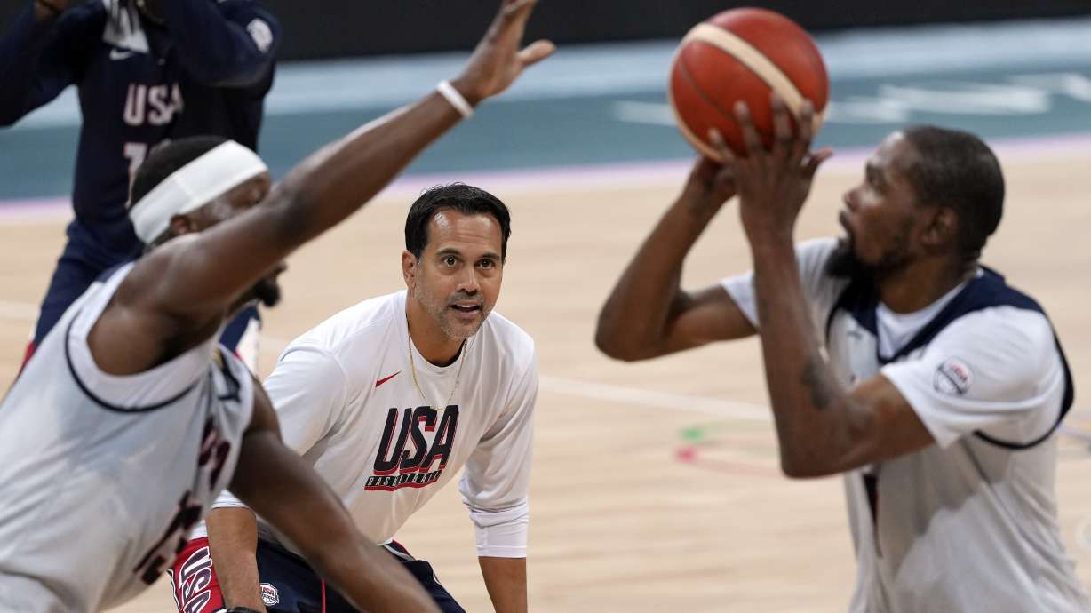 United State's Kevin Durant, right, shoots as Bam Adebayo, left, defends while assistant coach Erik Spoelstra watches during men's basketball practice at the 2024 Summer Olympics, Wednesday, July 24, 2024, in Villeneuve-d'Ascq, France.