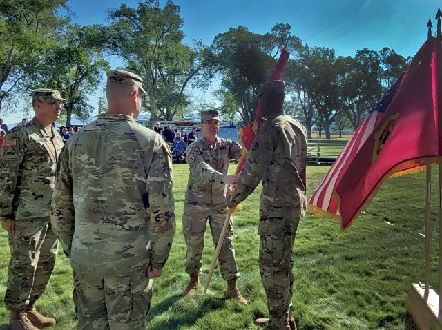 Christopher Reaves, far right, the command sergeant major of the Joint Munitions Command, passes the Tooele Army Depot flag off to Col. Luke Clover, TEAD’s new commander, during a change of command ceremony July 18.