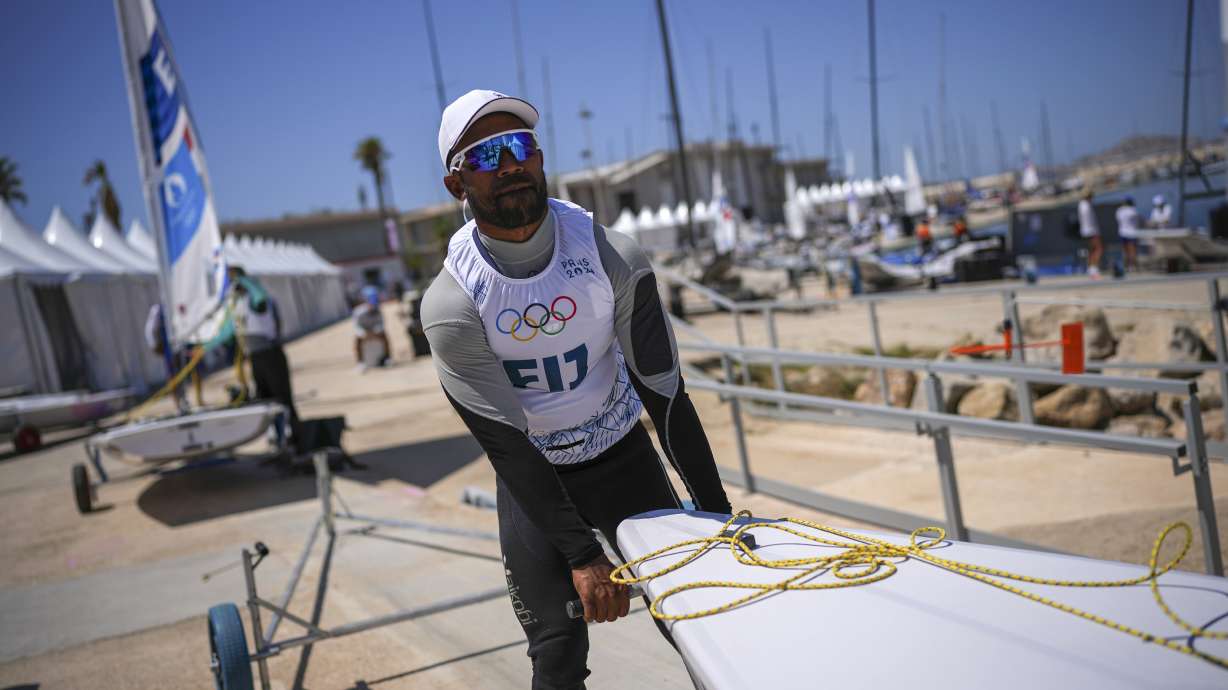 CORRECTS SPELLING OF FIRST NAME TO VILIAME NOT VILIAM - Fiji's Viliame Ratulu, competing in the men's dinghy sailing competition, prepares his dinghy for a practice session at the Marseille Marina during the 2024 Summer Olympics, Thursday, July 25, 2024, in Marseille, France.