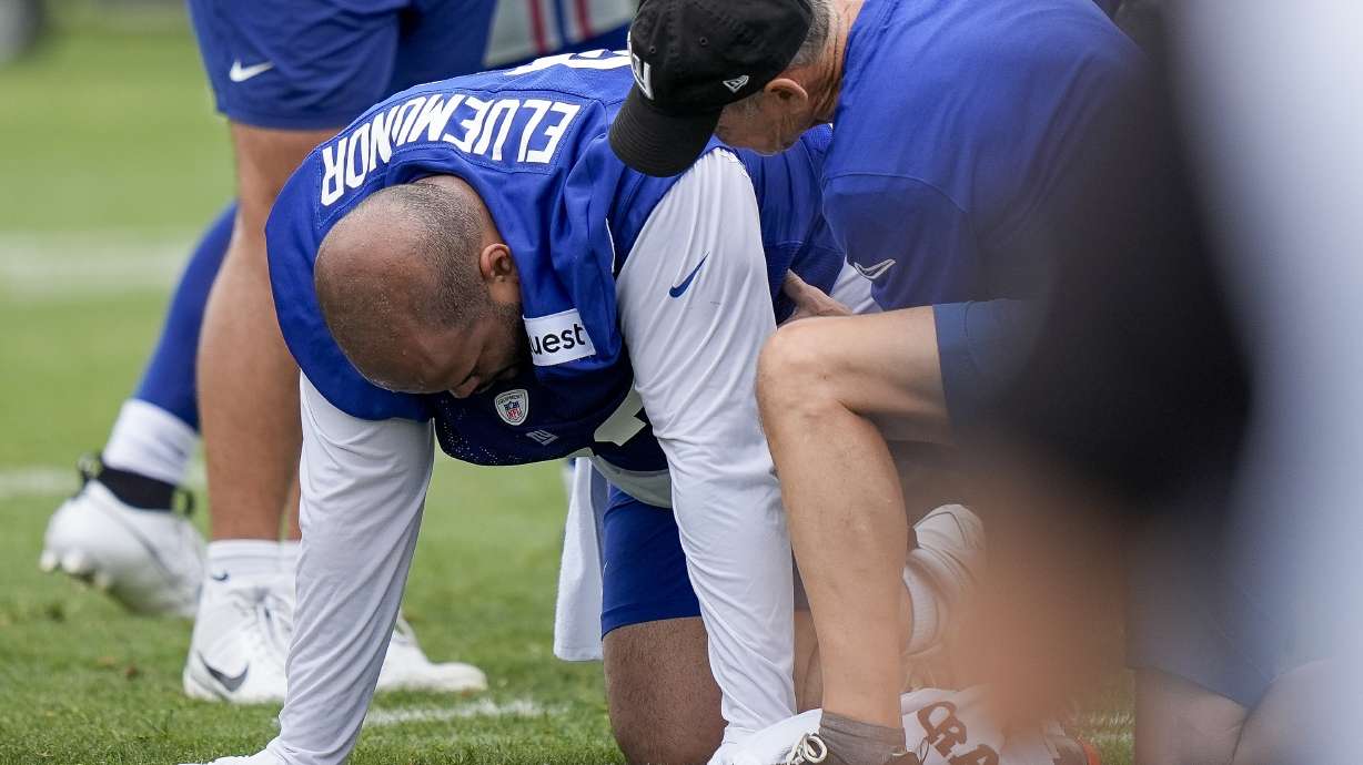 New York Giants tackle Jermaine Eluemunor is tended to by training staff after an injury during NFL football training camp, Wednesday, July 24, 2024, in East Rutherford, N.J.