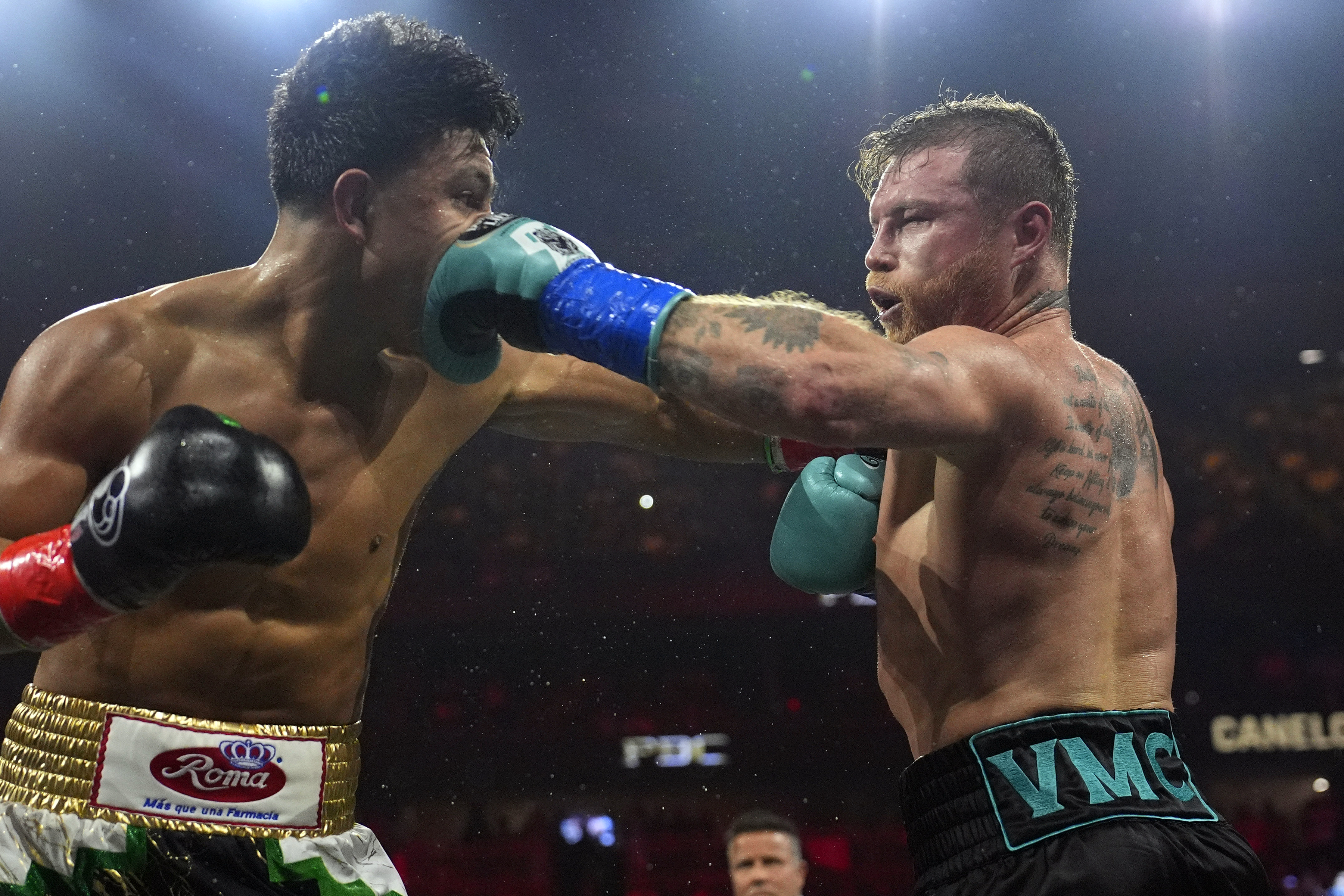 FILE - Canelo Alvarez, right, hits Jaime Munguia, left, during a super middleweight title fight May 4, 2024, in Las Vegas. Alvarez is to defend his super middleweight titles against Edgar Berlanga on Sept. 14, 2024, in Las Vegas as he returns for another fight during Mexican Independence Day weekend. 