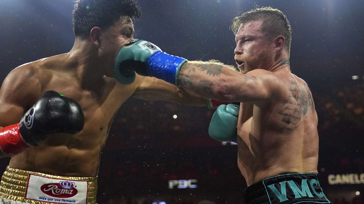 FILE - Canelo Alvarez, right, hits Jaime Munguia, left, during a super middleweight title fight May 4, 2024, in Las Vegas. Alvarez is to defend his super middleweight titles against Edgar Berlanga on Sept. 14, 2024, in Las Vegas as he returns for another fight during Mexican Independence Day weekend.
