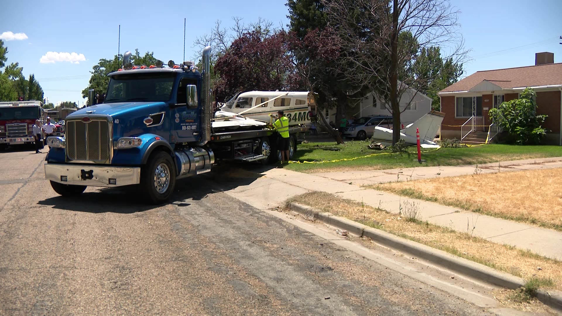 Crews loading plane on a trailer on Thursday after it crashed into a Roy neighborhood.