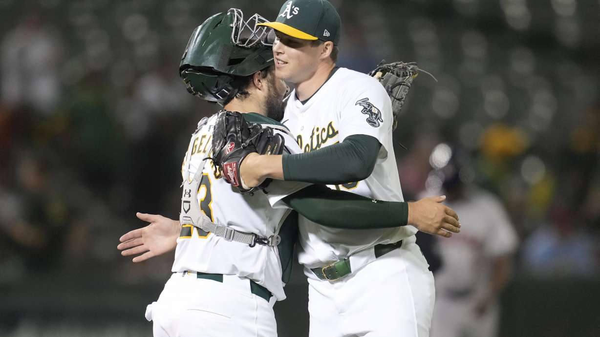Oakland Athletics catcher Shea Langeliers, left, celebrates with pitcher Mason Miller after the Athletics defeated the Houston Astros in a baseball game in Oakland, Calif., Monday, July 22, 2024.
