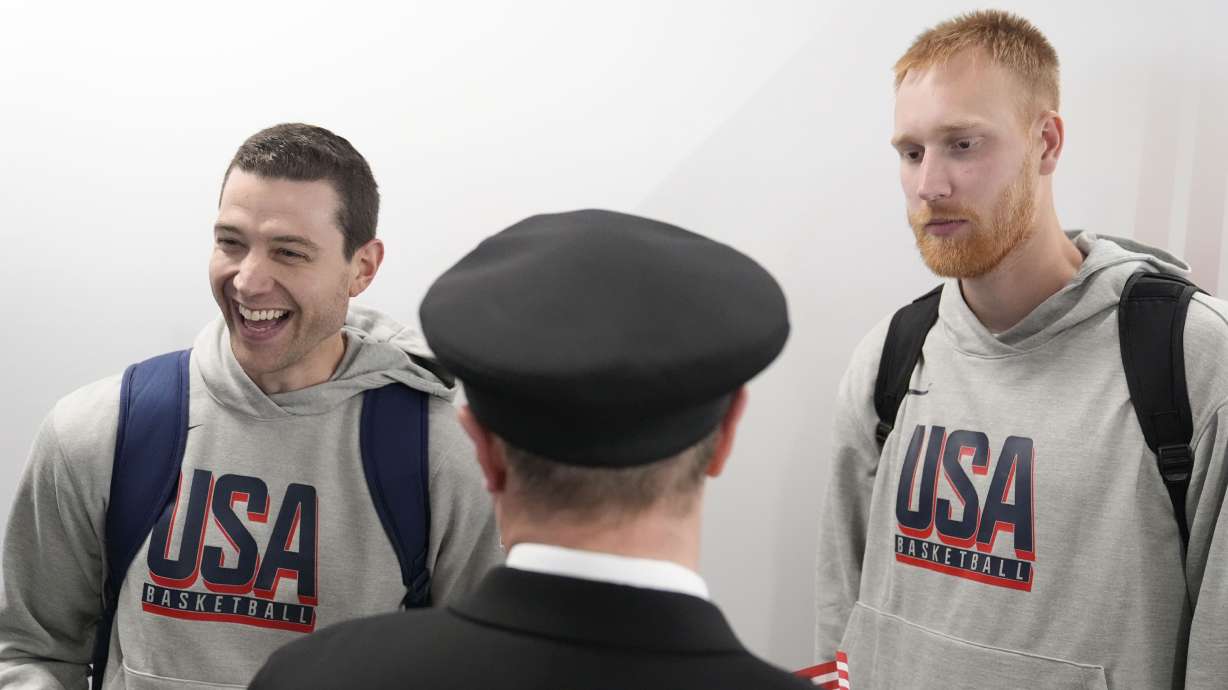 Team USA basketball athletes, Mitch Hahn, right, and Jimmer Fredette, talk with people before departing for the Paris Summer Olympic games, on Wednesday, July 17, 2024, in Atlanta.