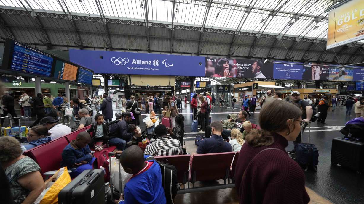 Travellers wait at the Gare de L'Est at the 2024 Summer Olympics, Friday, in Paris, France. Hours away from the grand opening ceremony of the Olympics, high-speed rail traffic was severely disrupted.