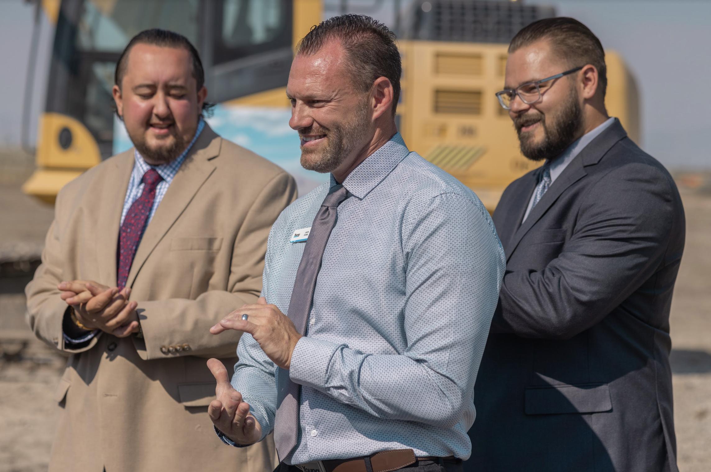 Jason Evans celebrates with Young Ford Brigham City sales consultants Dane Rogers (left) and Courd Larry Luke Jones (right) at groundbreaking ceremony.