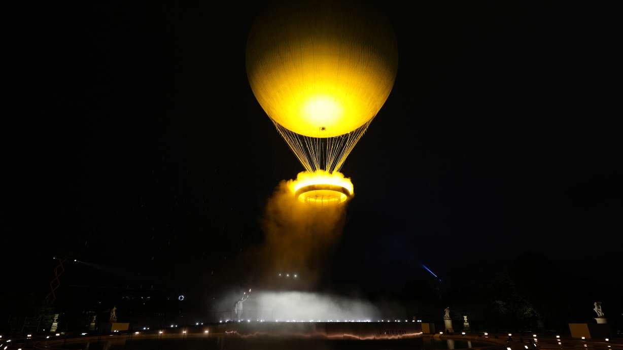 Teddy Riner and Marie-Jose Perec watch as the cauldron rises in a balloon in Paris, France, during the opening ceremony of the 2024 Summer Olympics, Friday, July 26, 2024.