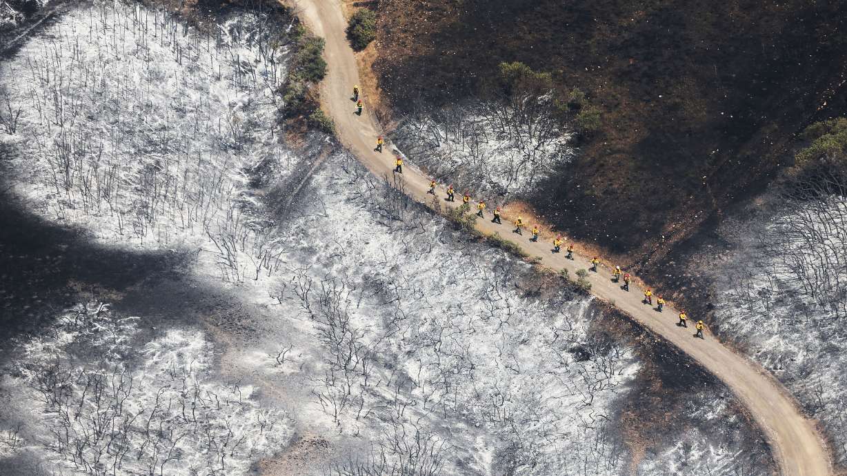 Firefighters walk through the Sandhurst Fire near Ensign Peak in Salt Lake City on Sunday.