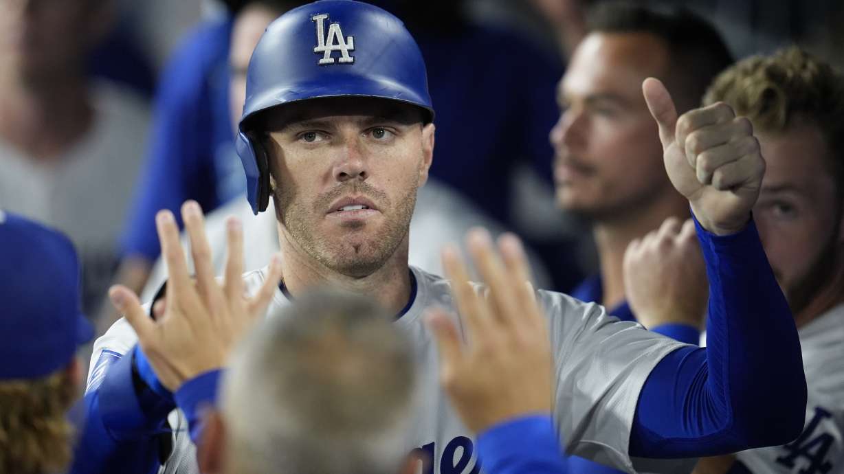 Los Angeles Dodgers' Freddie Freeman is high-fived in the dugout after scoring on a single by Teoscar Hernández during the sixth inning of a baseball game against the San Francisco Giants, Monday, July 22, 2024, in Los Angeles.