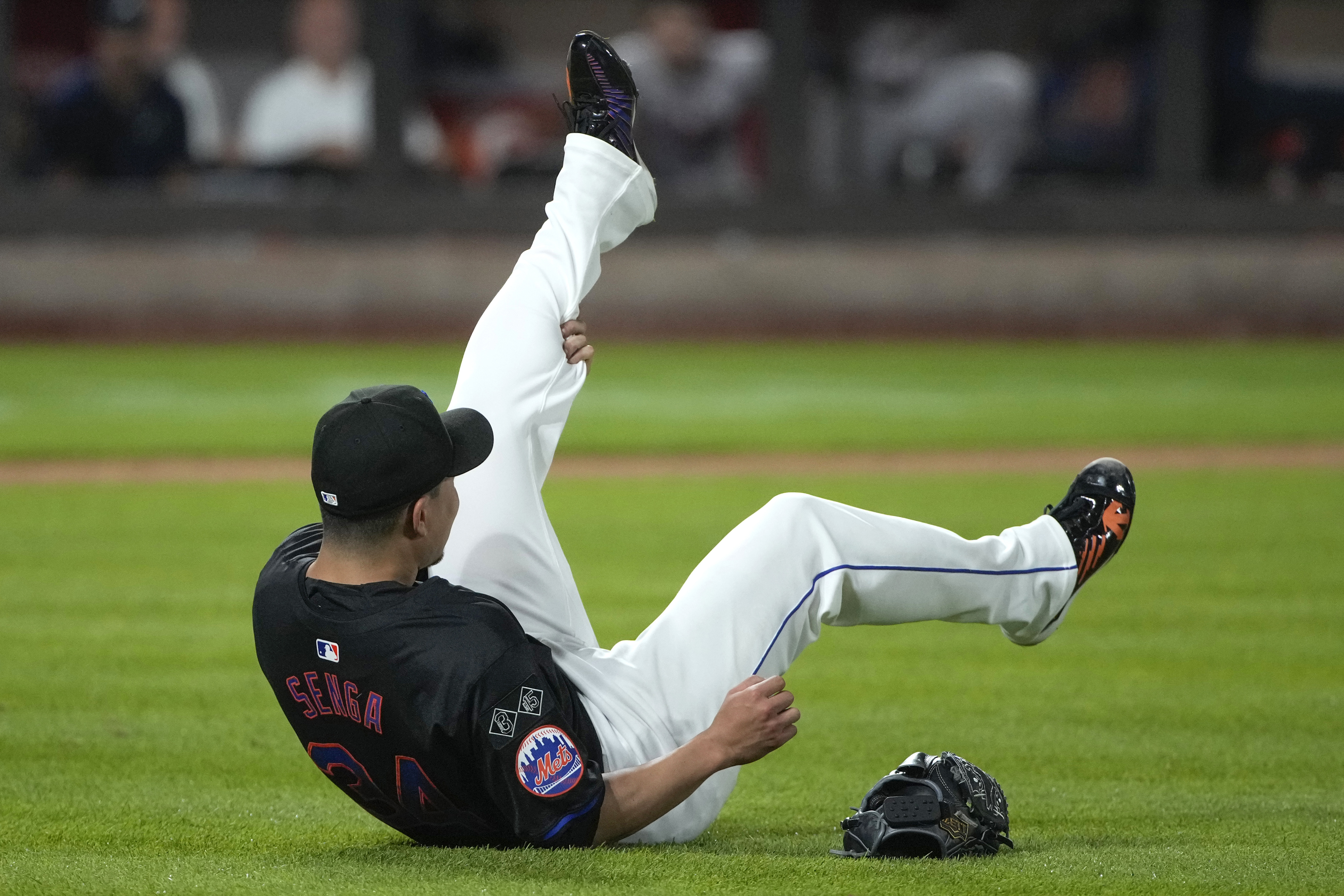 New York Mets' Kodai Senga grabs his leg as he reacts to an injury during the sixth inning of a baseball game against the Atlanta Braves, Friday, July 26, 2024, in New York.